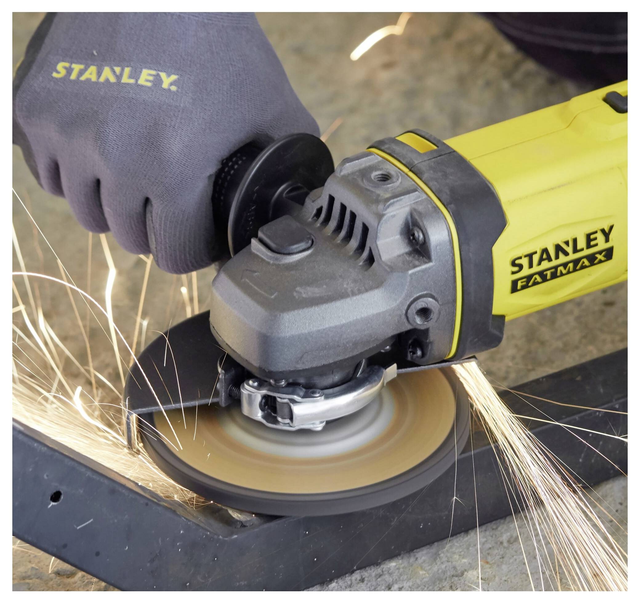 Eine Person benutzt einen gelben Stanley Fatmax Winkelschleiffer, um Metall durchzuschneiden, wobei beim Kontakt Funken entstehen.