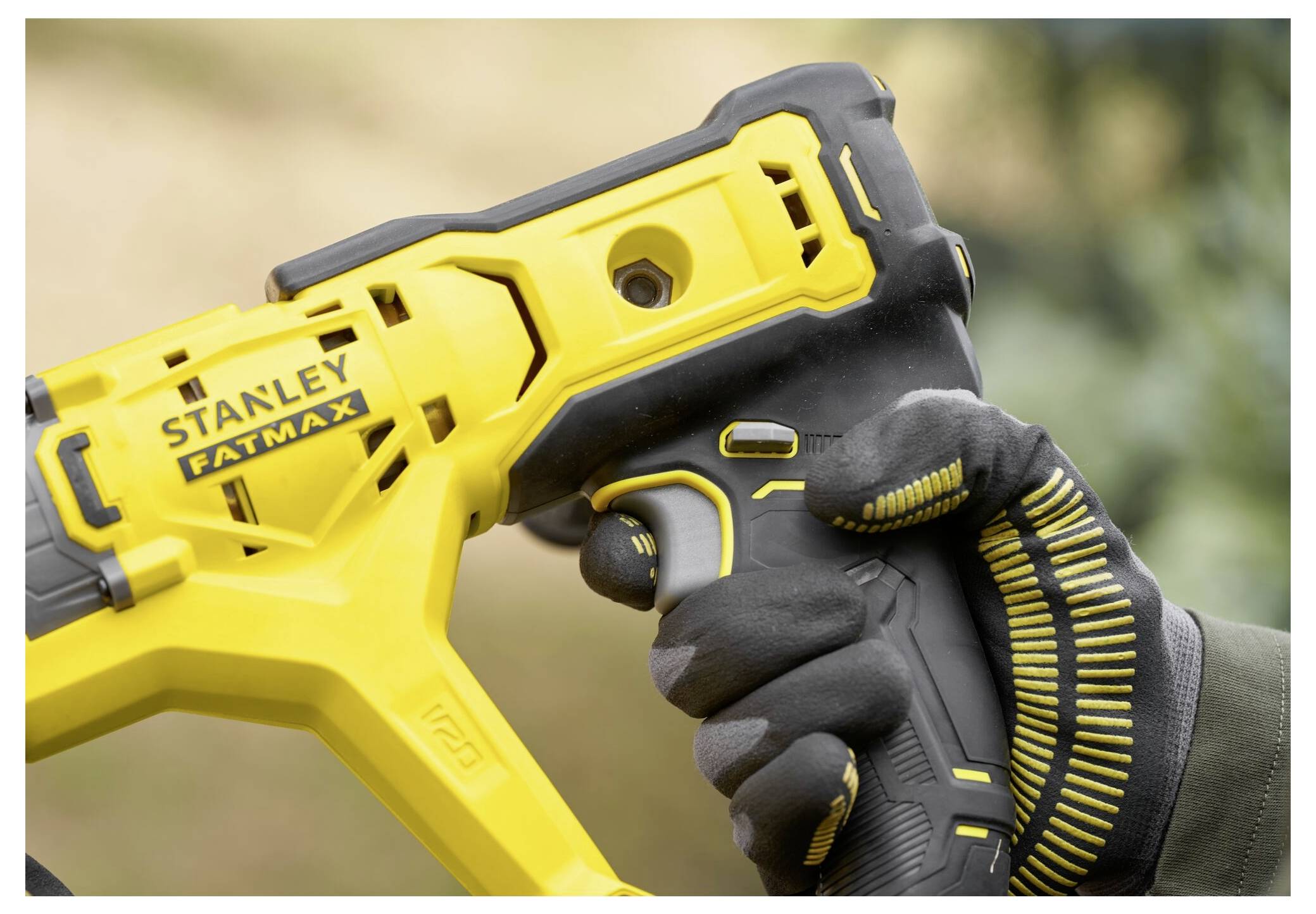 Eine behandschuhte Hand hält ein gelb-schwarzes Elektrowerkzeug mit sichtbarem 