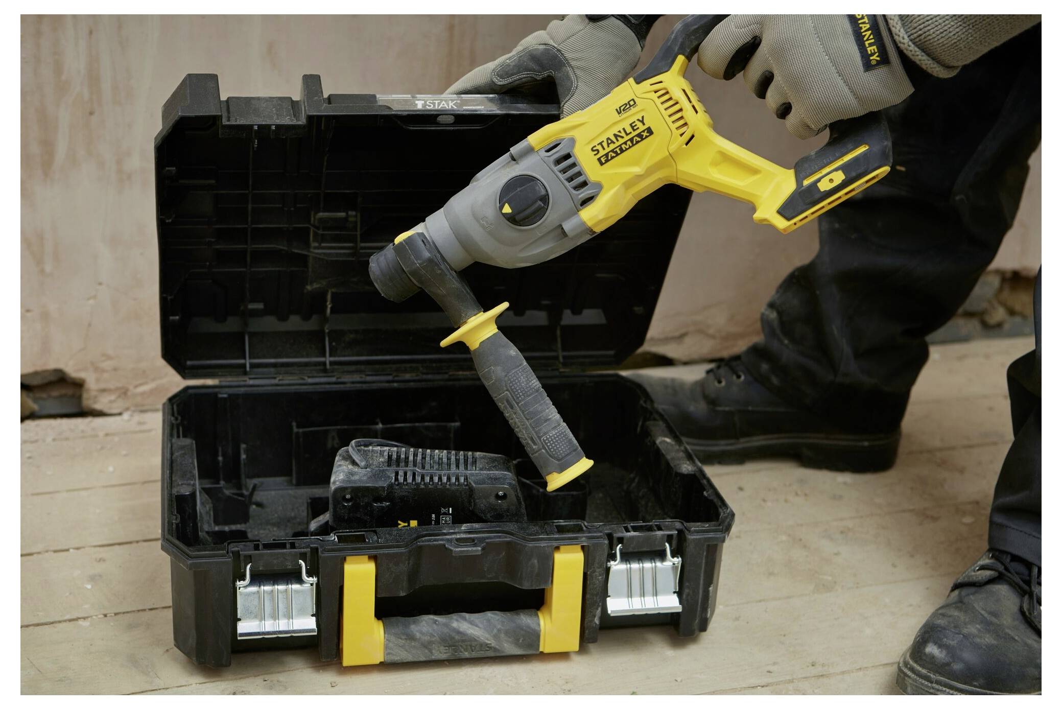 Person verwendet ein Stanley Fatmax Elektroschleifergerät auf einer Metalloberfläche in einer Werkstatt, mit einem Hobel-Werkzeug im Hintergrund sichtbar.