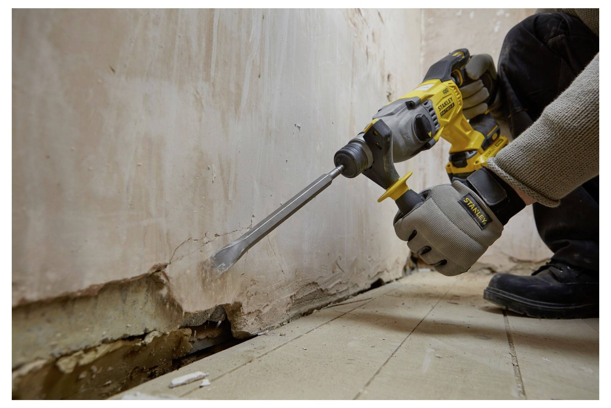 Behandschuhte Hände stellen einen gelben Tiefenstopp an einem Elektroschrauber ein, wobei der Fokus auf Präzision und Kontrolle in einem Bau- oder DIY-Umfeld liegt.