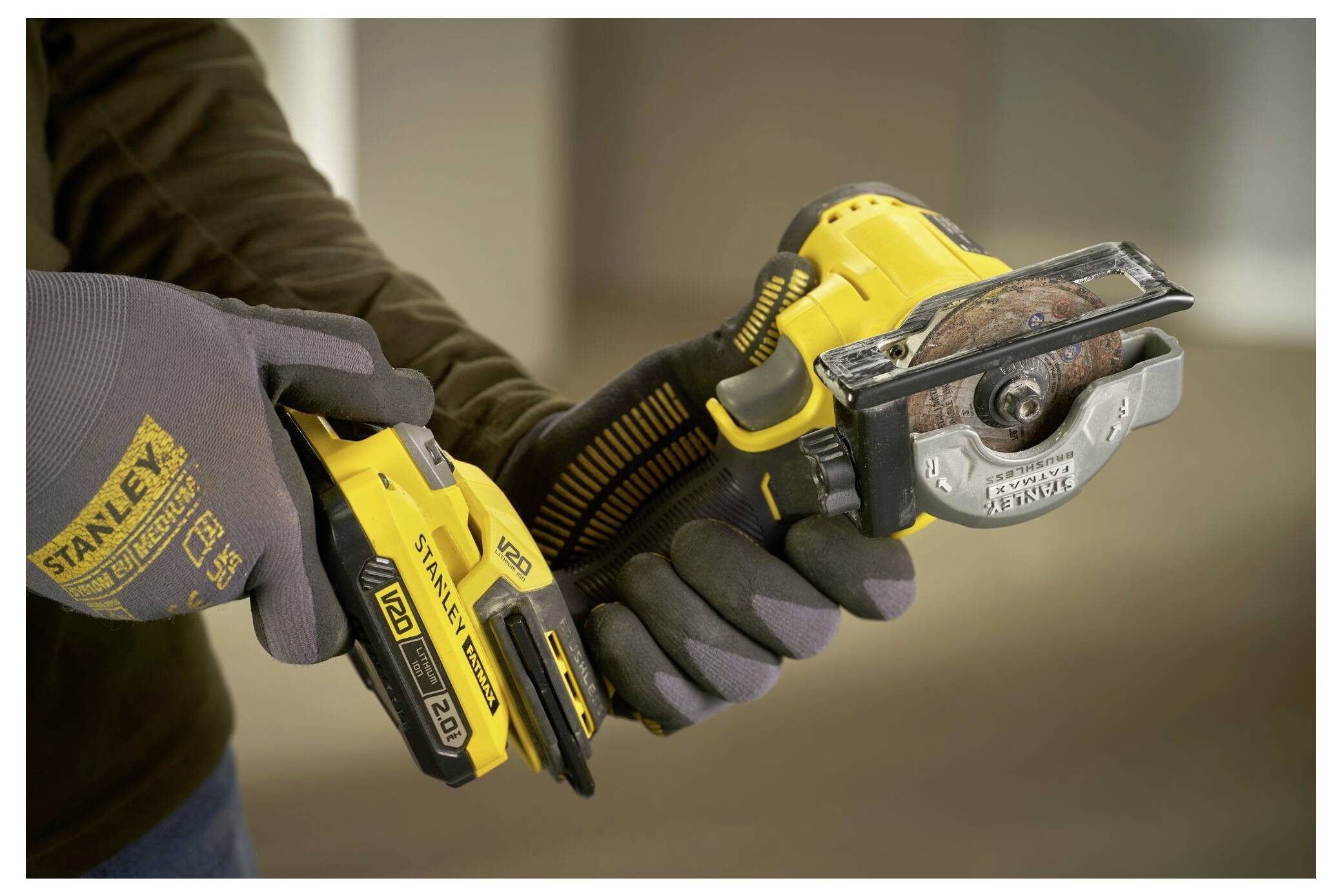 Eine Person benutzt ein gelb-schwarzes kabelloses Elektrowerkzeug zum Zuschneiden von Material und trägt dabei Schutzhandschuhe aus Sicherheitsgründen.