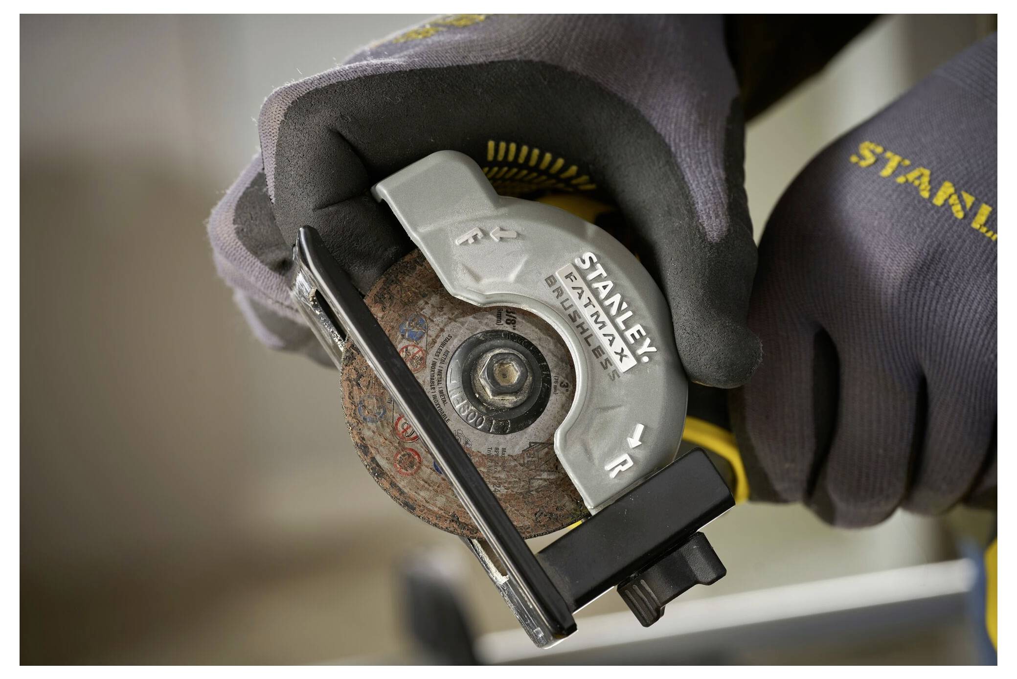 Jemand mit Handschuhen hält ein Elektrowerkzeug, speziell eine Kreissäge mit 