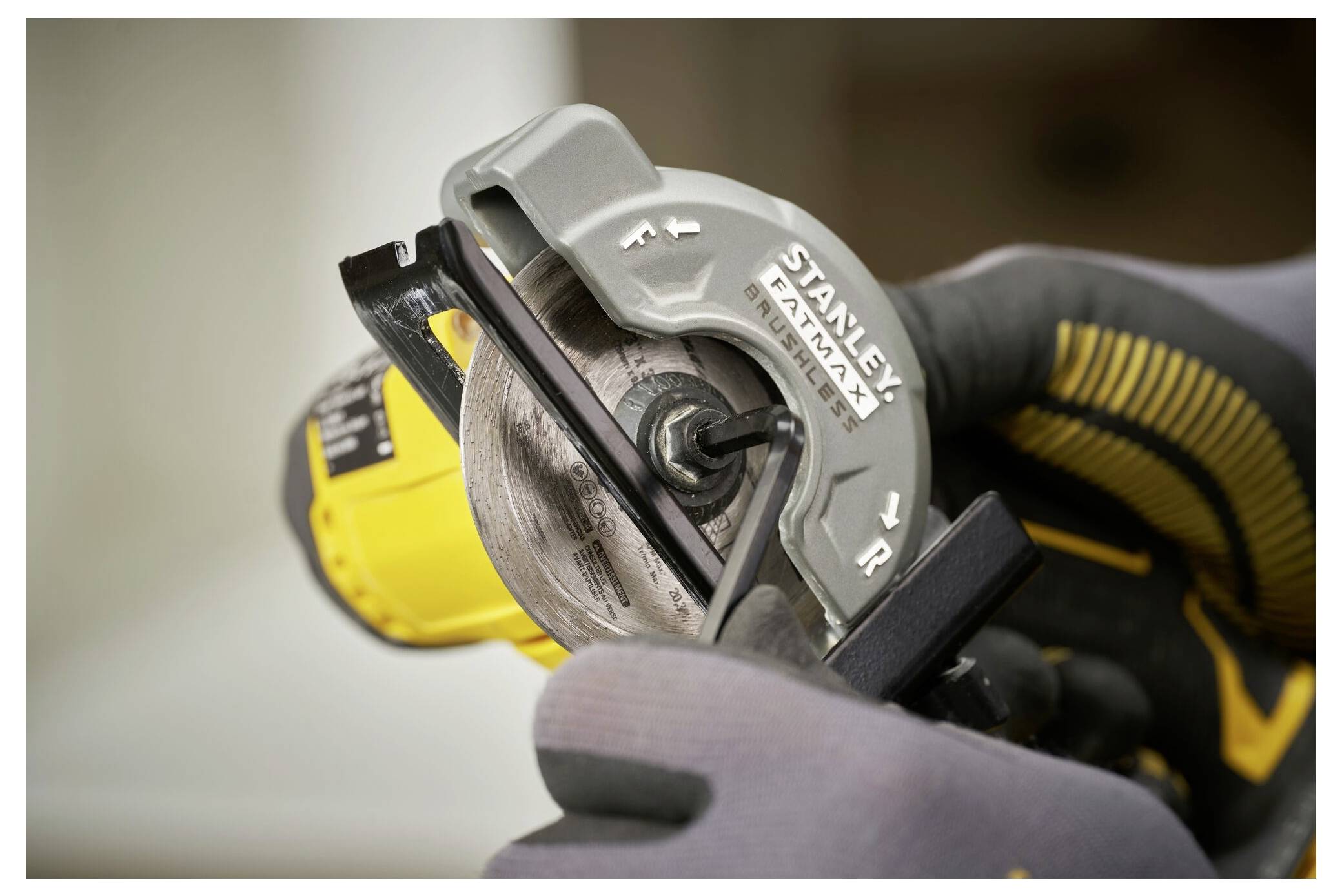 Eine Nahaufnahme von Händen mit Handschuhen, die ein Stanley FatMax-Werkzeug halten, was die Klingenausrichtung des Werkzeugs für präzises Schneiden anzeigt.