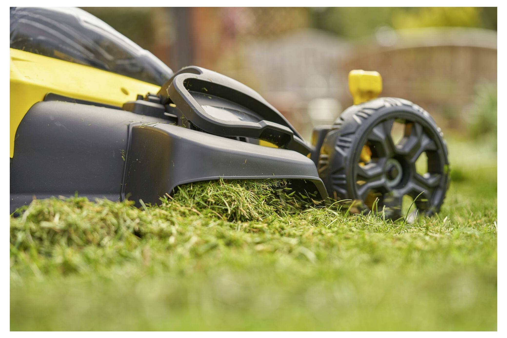 Eine behandschuhte Hand lötet eine Komponente auf eine grüne Leiterplatte. Eine gelbe Lötstation und eine weitere Leiterplatte befinden sich im Hintergrund.