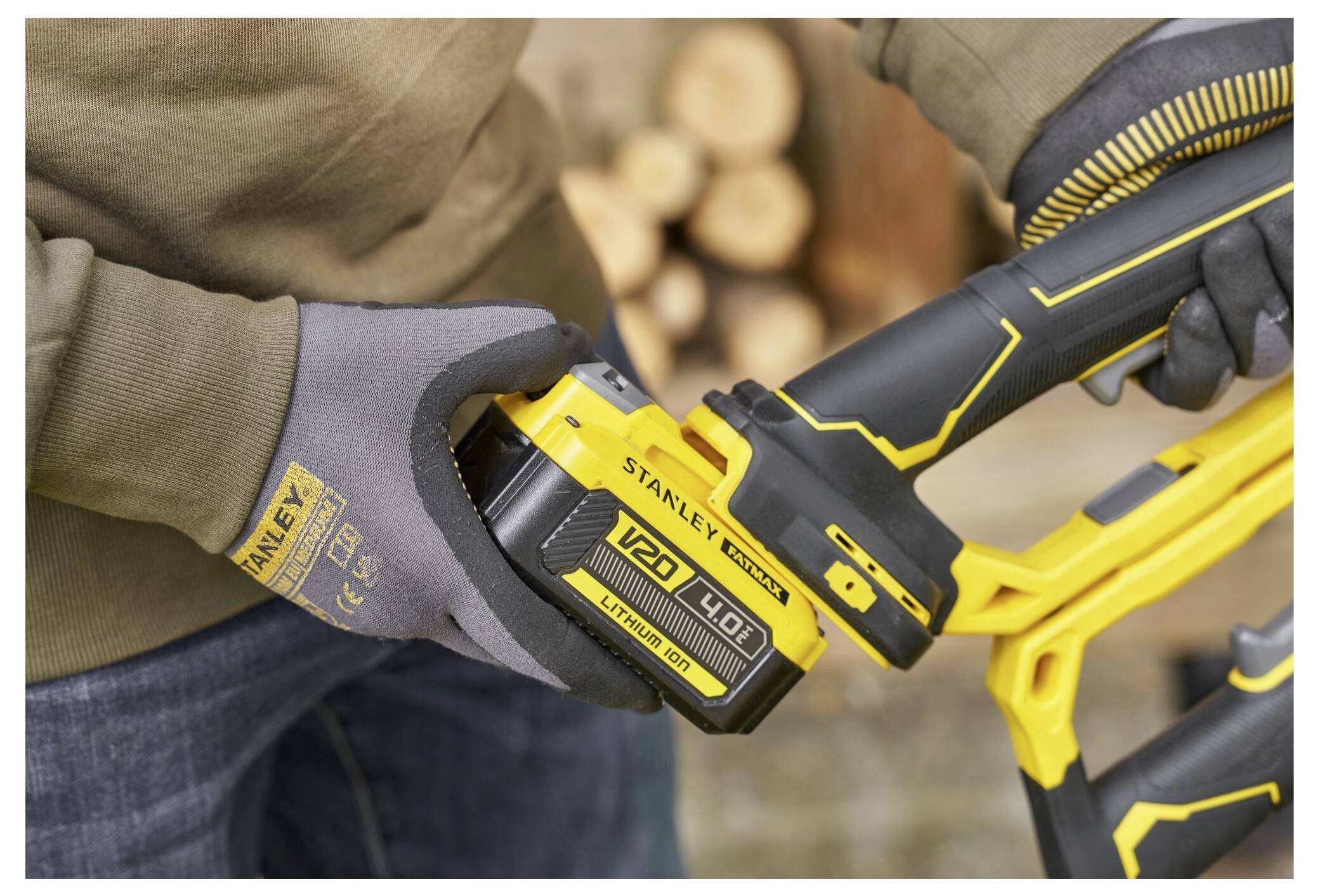 Eine Person setzt eine Stanley-Lithiumbatterie in ein schnurloses Elektrowerkzeug ein und demonstriert dabei die Benutzerfreundlichkeit und Kompatibilität mit dem Werkzeug.