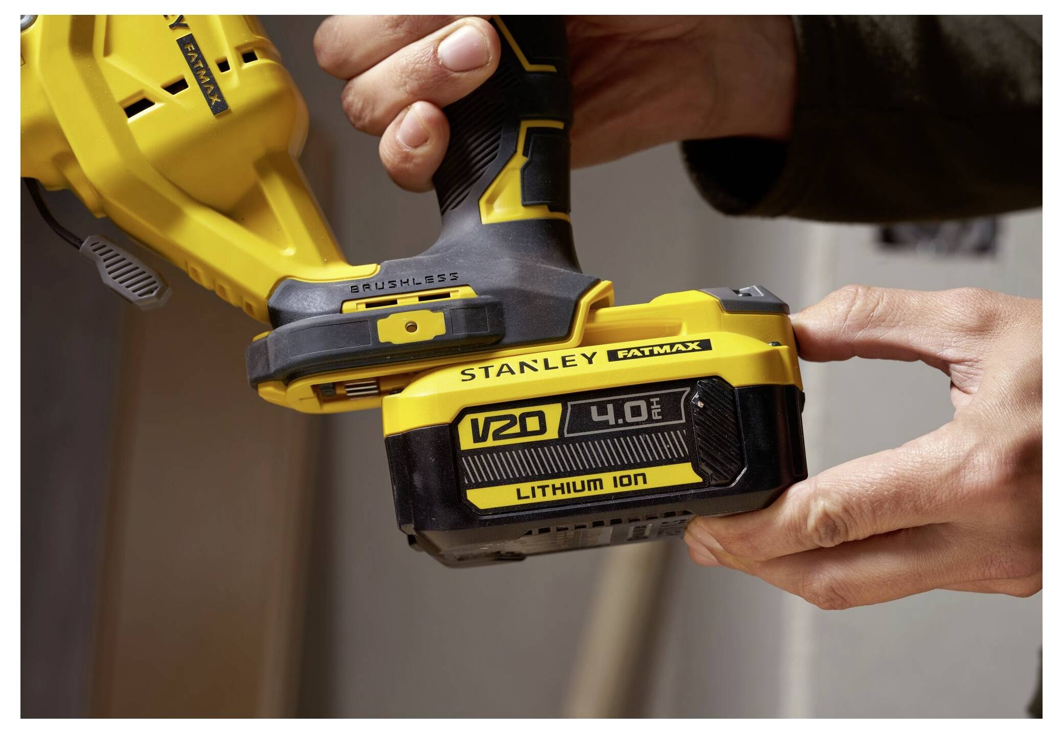 Eine Person hält ein gelbes kabelloses Werkzeug der Marke 