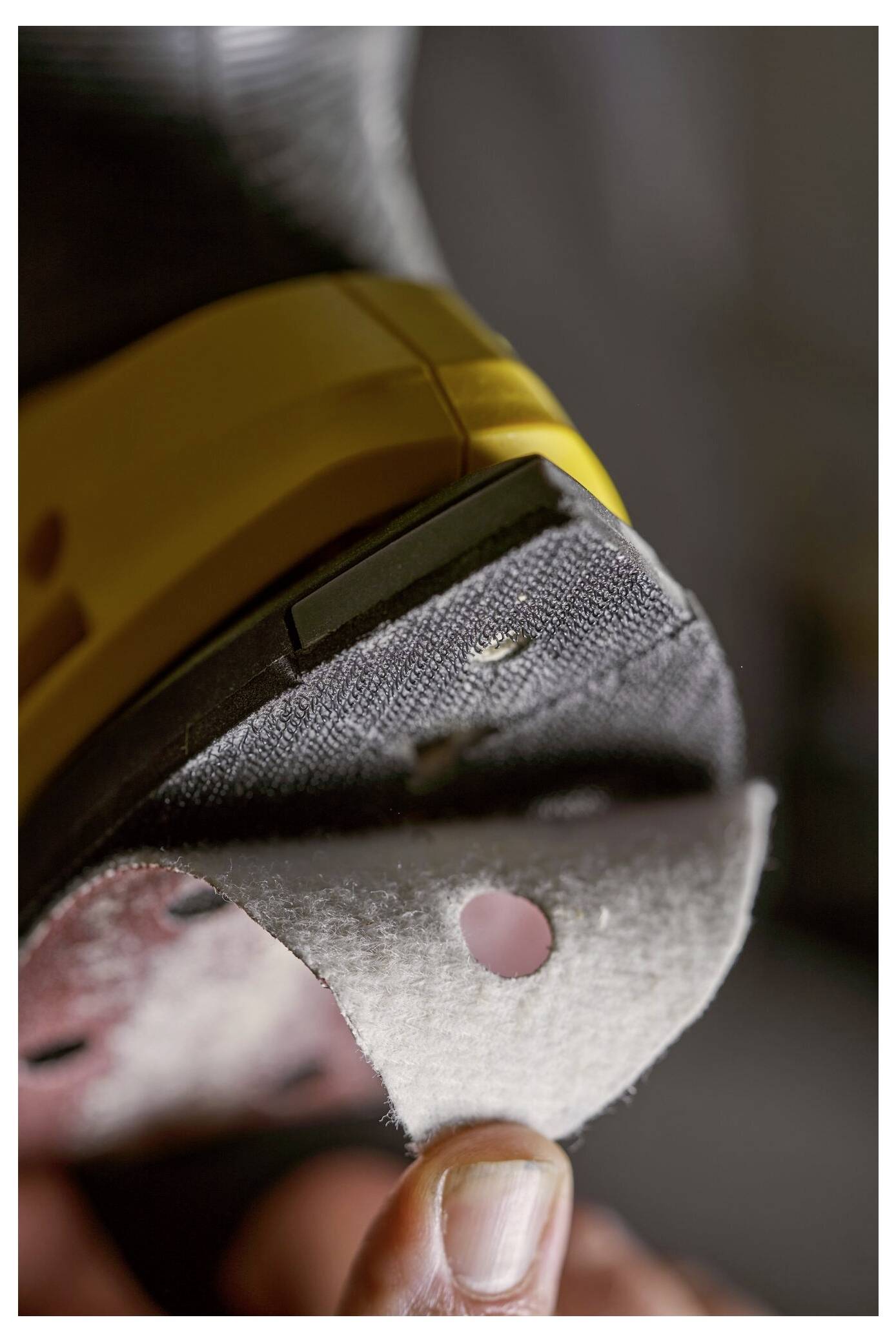 Eine Person hält eine abgetragene Schuhsohle, die einen Ausschnitt und eine abgelaufene Ferse mit einem gelben Bereich aufweist, was auf die Notwendigkeit einer Schuhreperatur oder eines Schuhaustauschs hindeutet.