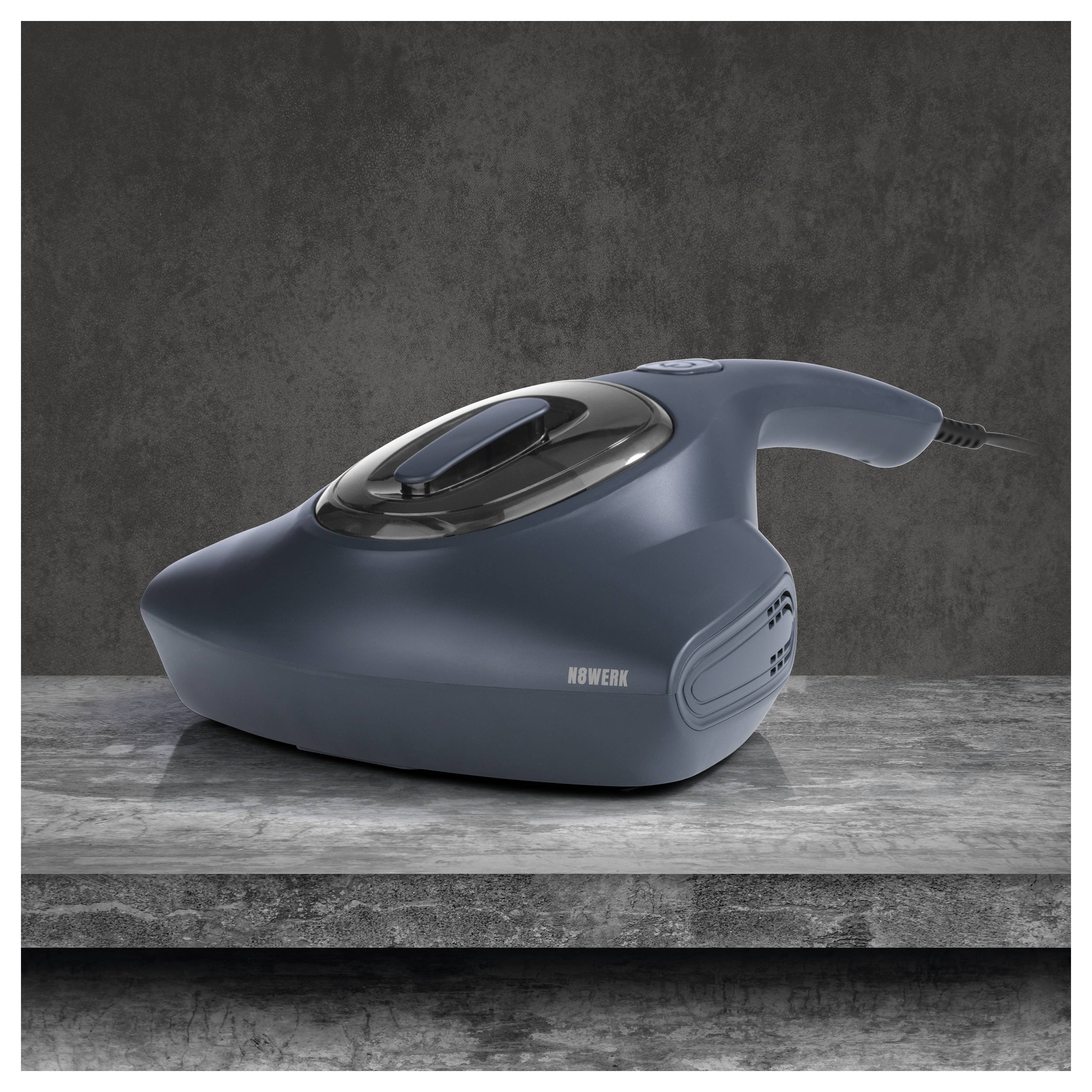 Ein dunkelblauer tragbarer Staubsauger ruht auf einer grauen Marmorfläche und zeichnet sich durch ein elegantes Design mit einer oberen Taste und seitlichen Luftschlitzen aus.