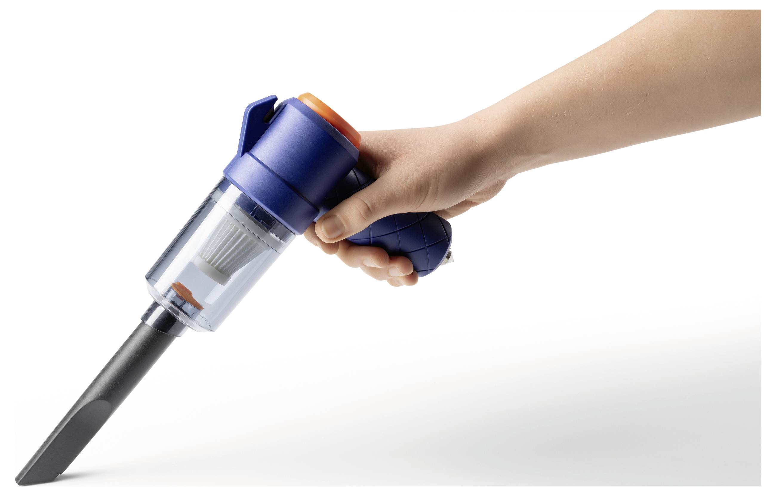 Eine Hand hält einen tragbaren Staubsauger mit einem durchsichtigen Staubbehälter und einer schmalen Düse, die in einem Winkel auf eine weiße Oberfläche gerichtet ist.