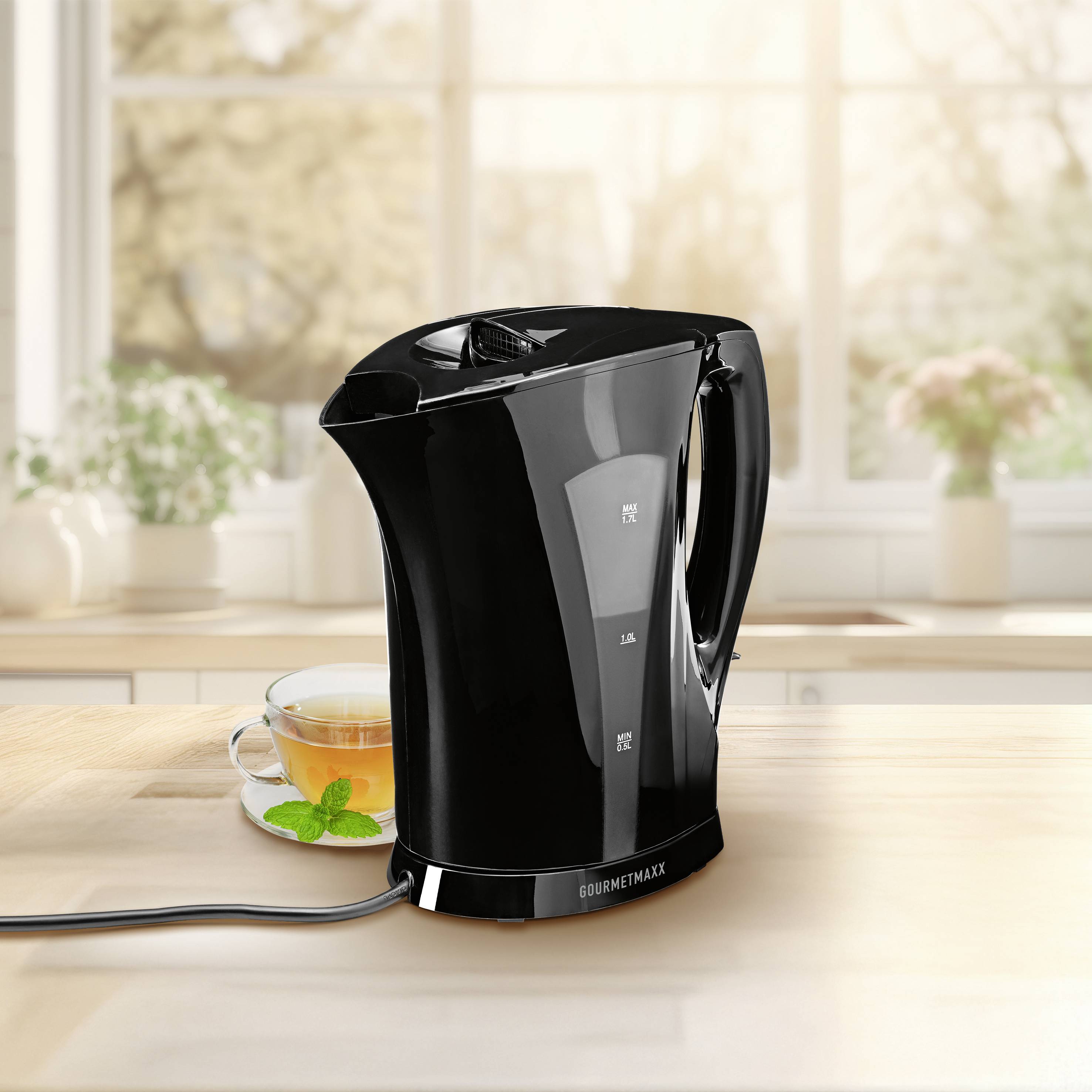 Ein eleganter schwarzer Elektrokocher mit glänzender Oberfläche und sichtbaren Markierungen für maximales und minimales Wasserniveau. Das Kabel ist an der Basis angebracht.