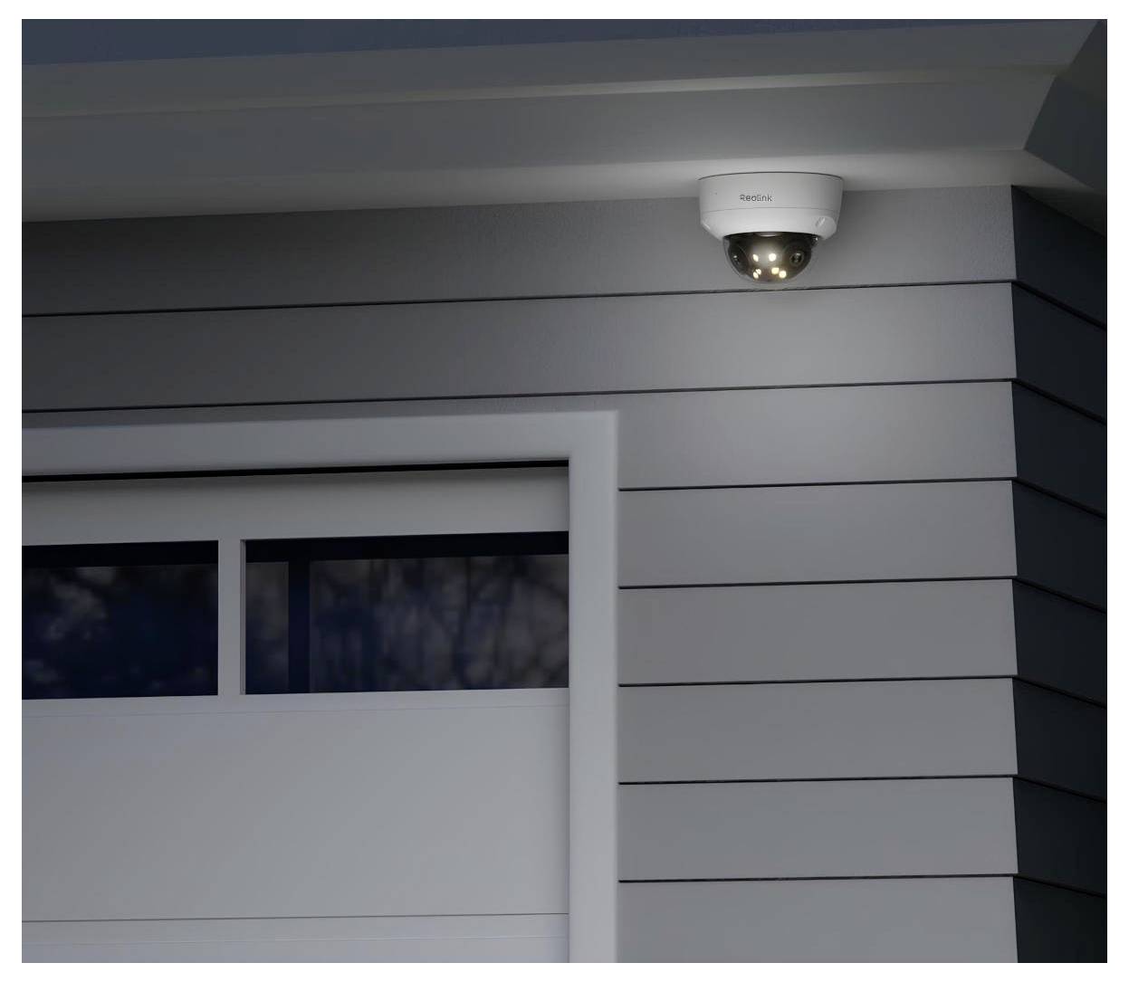 Sicherheitskamera an der Außenwand eines Gebäudes montiert, mit sichtbaren LED-Leuchten, die anzeigen, dass sie aktiv ist und überwacht.