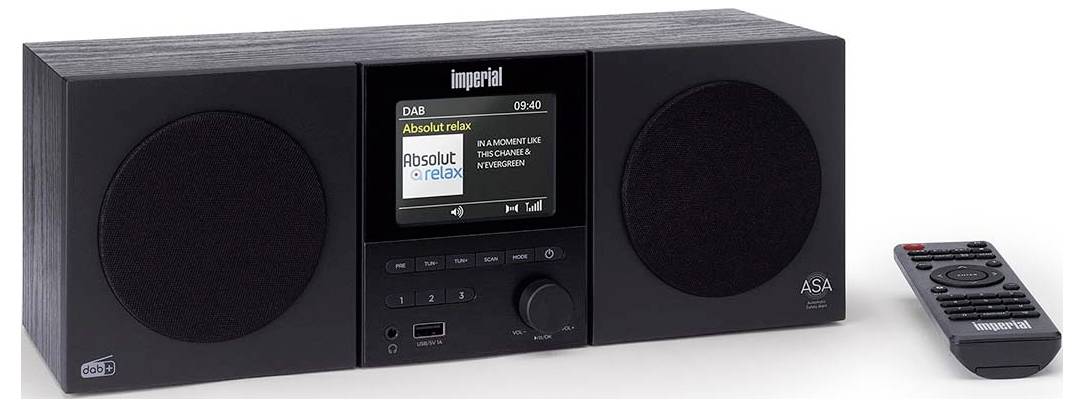 Ein schwarzes Tischradio mit zwei Lautsprechern, einem digitalen Display und Bedienschaltflächen. Eine Fernbedienung liegt daneben.