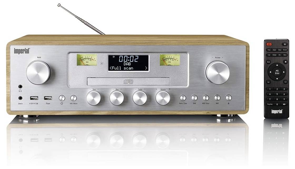 Ein silberner Radioempfänger mit Holzoptik, der auf dem Display 'DAB Full Scan' anzeigt. Beinhaltet runde Bedienknöpfe und eine Fernbedienung.