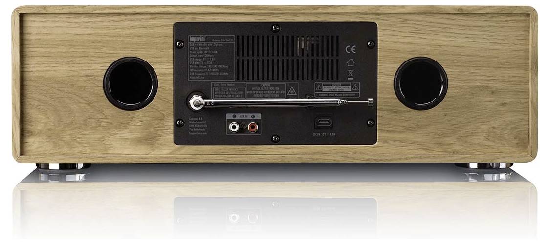 Das Bild zeigt die Rückseite eines Holzlautsprechersystems mit Anschlussanschlüssen, einer Antenne, Belüftungsgittern und zwei kreisförmigen Seitenlautsprechern.