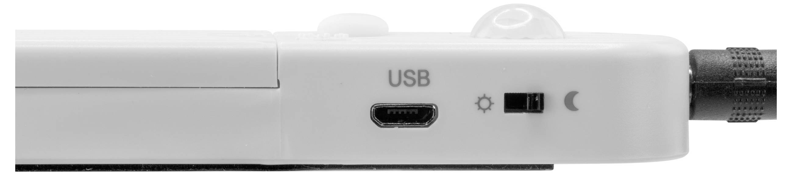 Nahaufnahme eines weißen Seitenpanels eines Geräts mit einem USB-Anschluss, einem kleinen Schalter neben Sonne- und Mondsymbolen und einem angeschlossenen Kabel auf der rechten Seite.