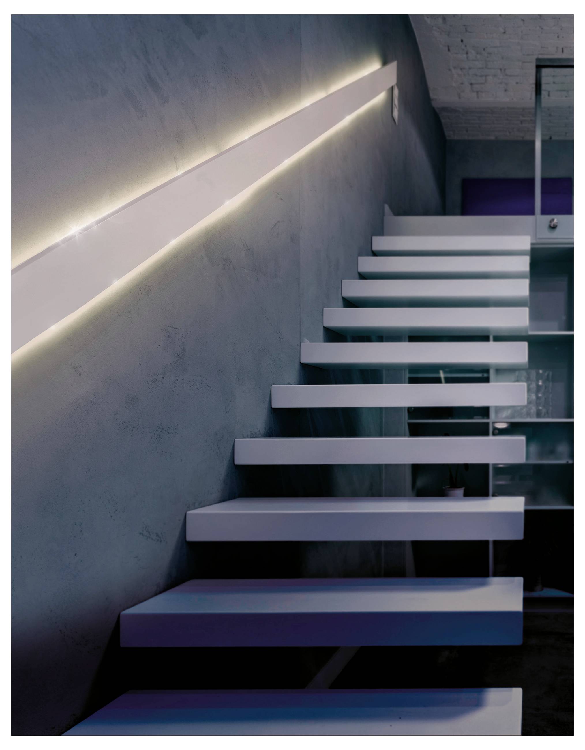 Moderne freischwebende Treppe mit weißen Stufen, die neben einer beleuchteten grauen Wand in einem schlanken Innenraum aufsteigt.