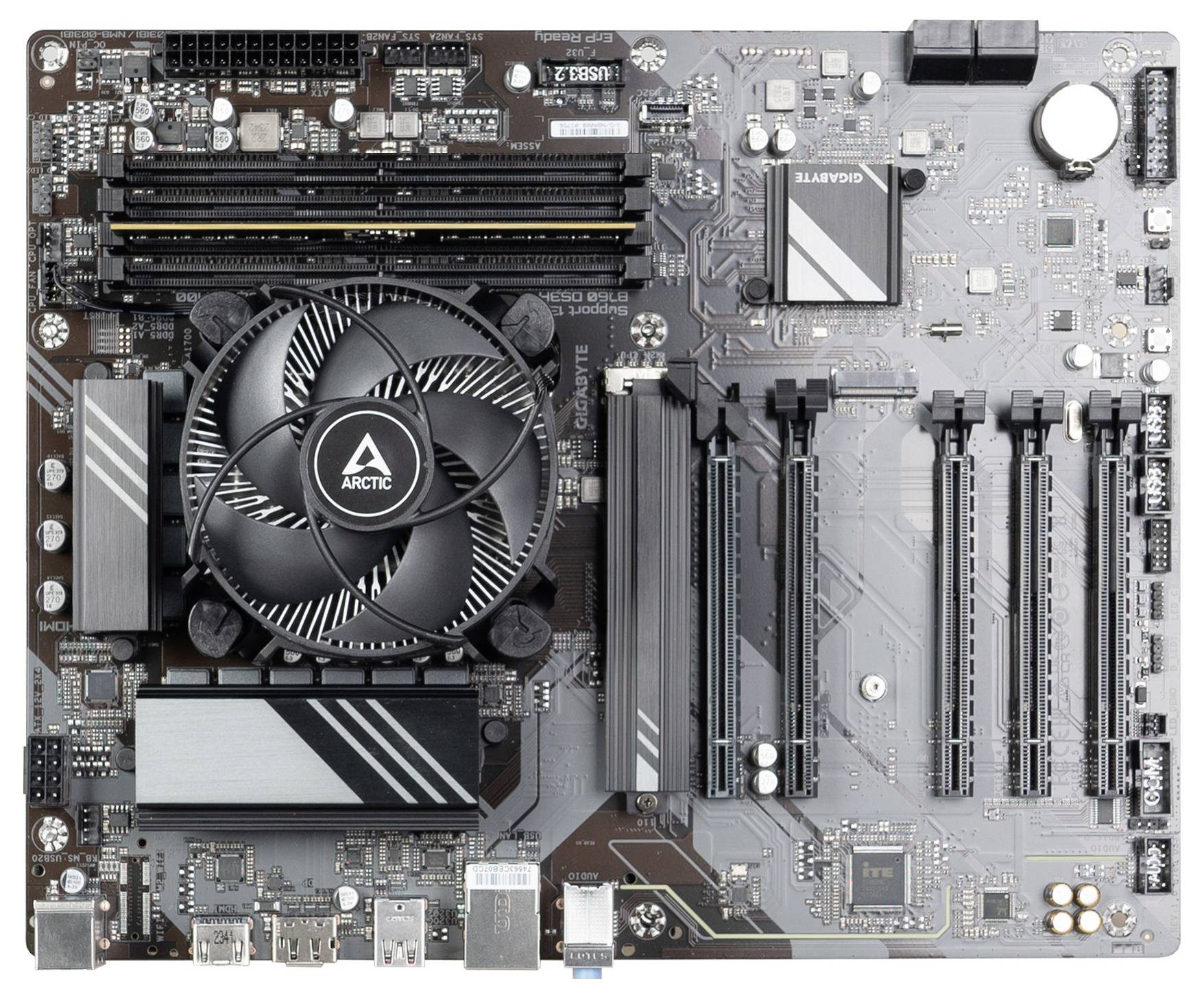 Draufsicht auf ein Computer-Motherboard mit CPU-Kühler, vier RAM-Steckplätzen, mehreren PCIe-Steckplätzen und hinteren Ein-/Ausgabe-Anschlüssen.