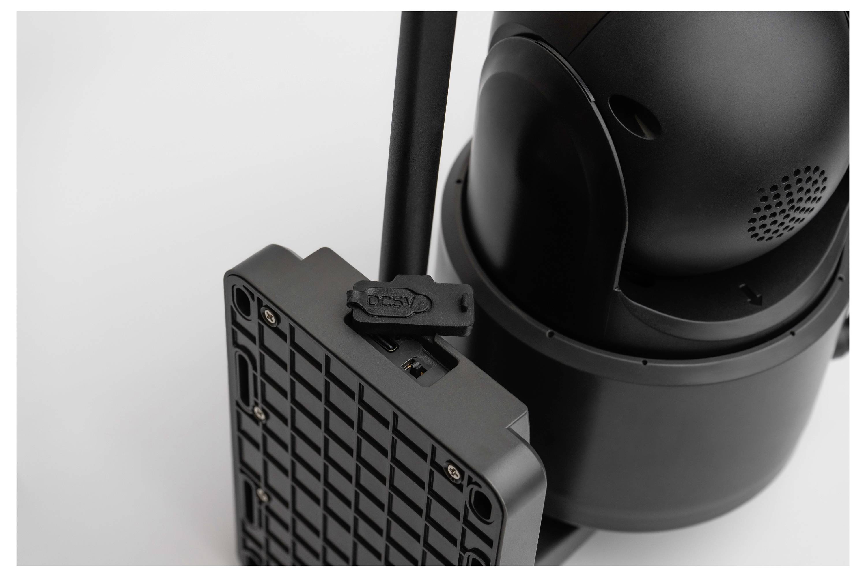 Ein schwarzes elektronisches Gerät mit einer kastenförmigen Komponente angebracht, mit Tasten und Anschlüssen ausgestattet, was auf einen Verbindungs- oder Stromversorgungsaufbau hindeutet.