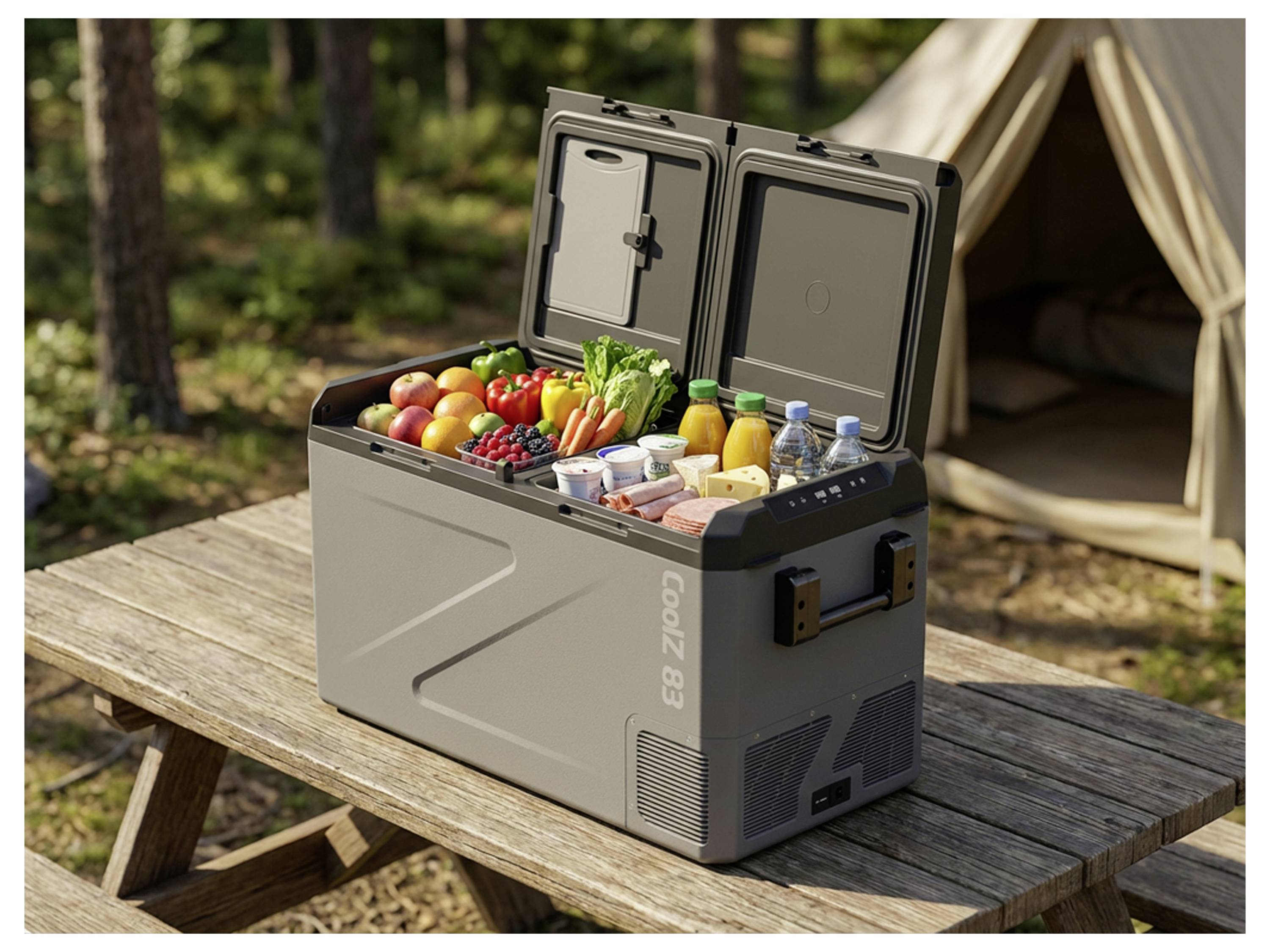 Tragbarer Kühlbox gefüllt mit frischen Lebensmitteln und Getränken auf einem Picknicktisch neben einem Zelt auf einem Campingplatz.