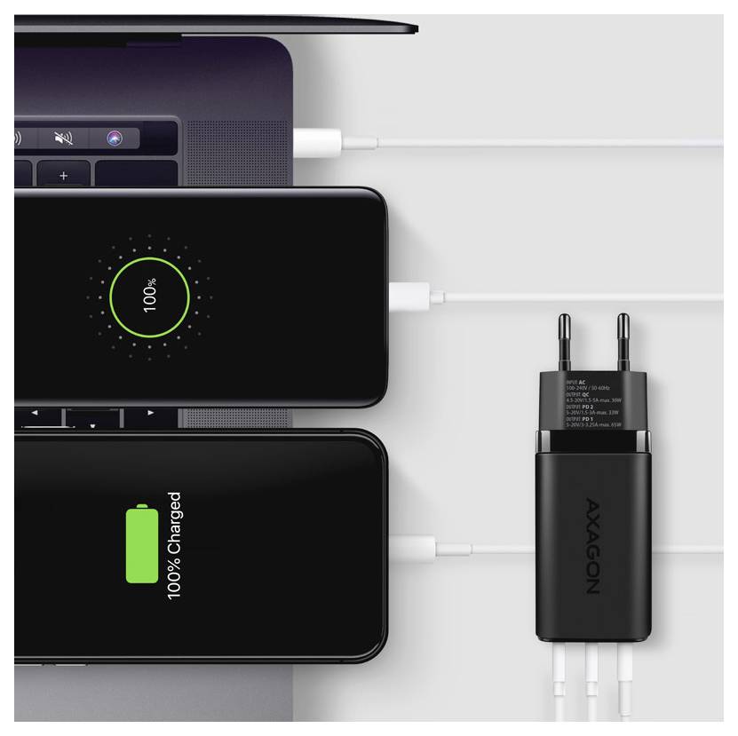 Drei Smartphones laden von einem Mehrfach-Wandladegerät; eines zeigt 100% an und ein anderes „100% Geladen
