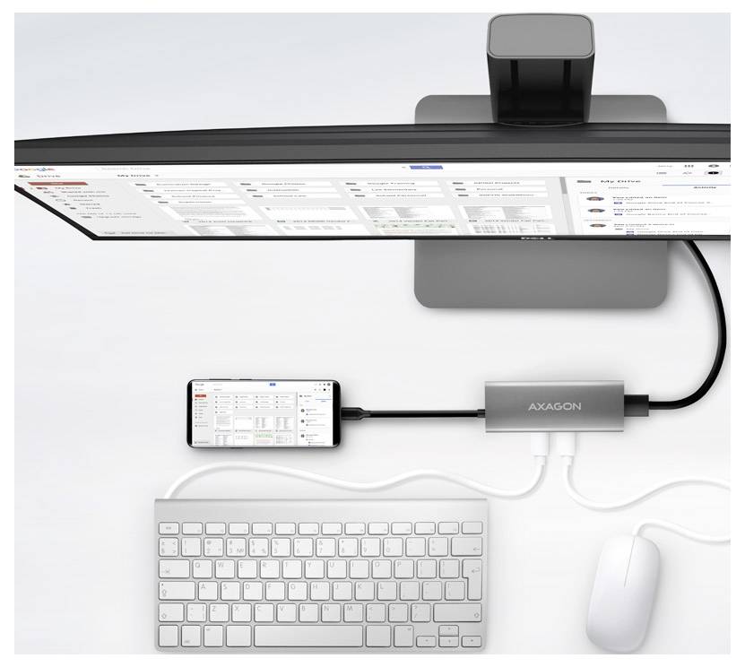 Draufsicht auf einen Desktop-Setup mit einem Ultrawide-Monitor, Telefon, Tastatur und Maus, die über einen AXAGON-Docking-Hub mit Kabeln verbunden sind.