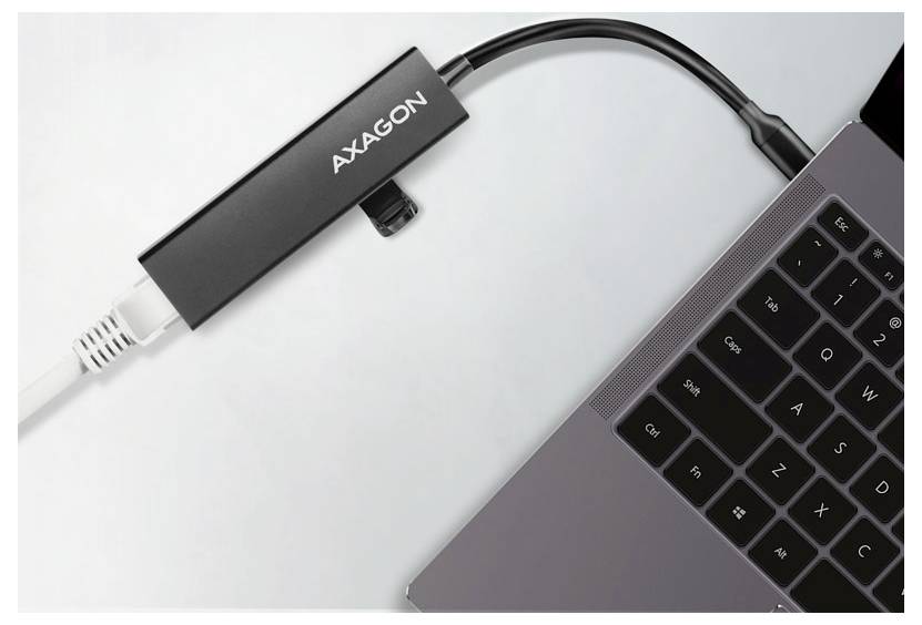 AXAGON USB-C-Adapter, der mit einem Laptop verbunden ist, mit einem weißen Kabel, das in den Adapter eingesteckt ist, und einem schwarzen Kabel, das zum Computer führt.