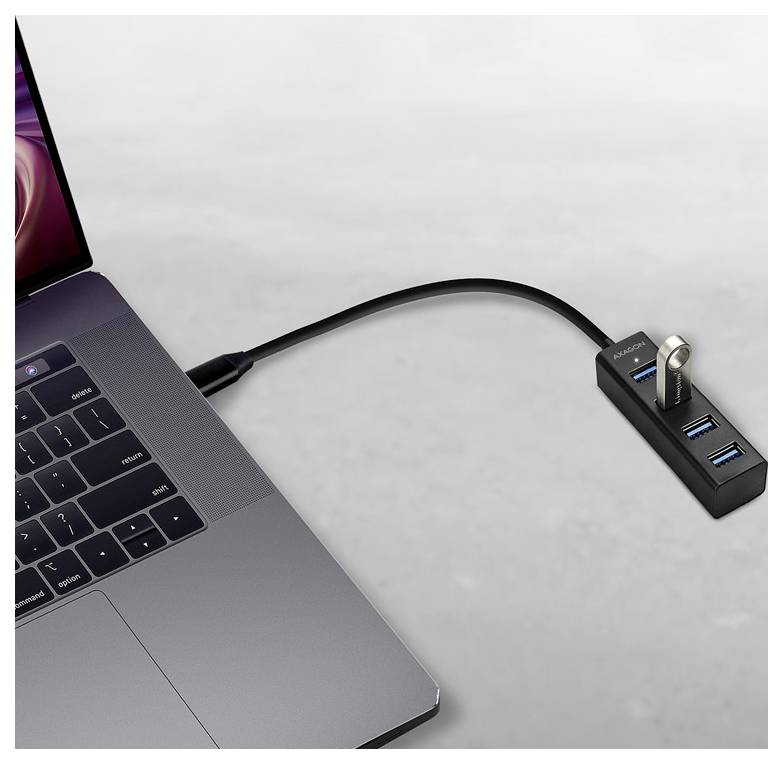 Laptop, das über ein USB-C-Kabel mit einem kleinen Hub mit mehreren USB-Anschlüssen und einem eingesteckten USB-Stick verbunden ist.