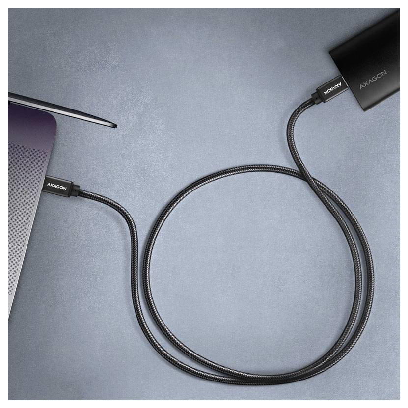 Schwarzes geflochtenes USB-C-Kabel verbindet einen Laptop mit einem externen AXAGON-Gerät auf einer blauen Oberfläche.