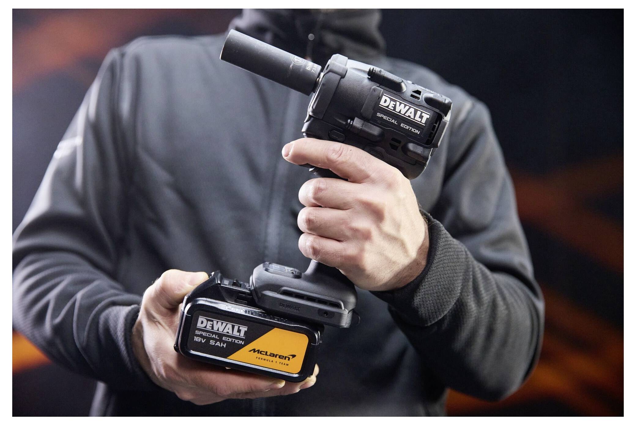 Eine Person hält ein schnurloses Elektrowerkzeug von DEWALT und ein Akkupack und zeigt das Werkzeug und die Markenbezeichnung aus nächster Nähe.