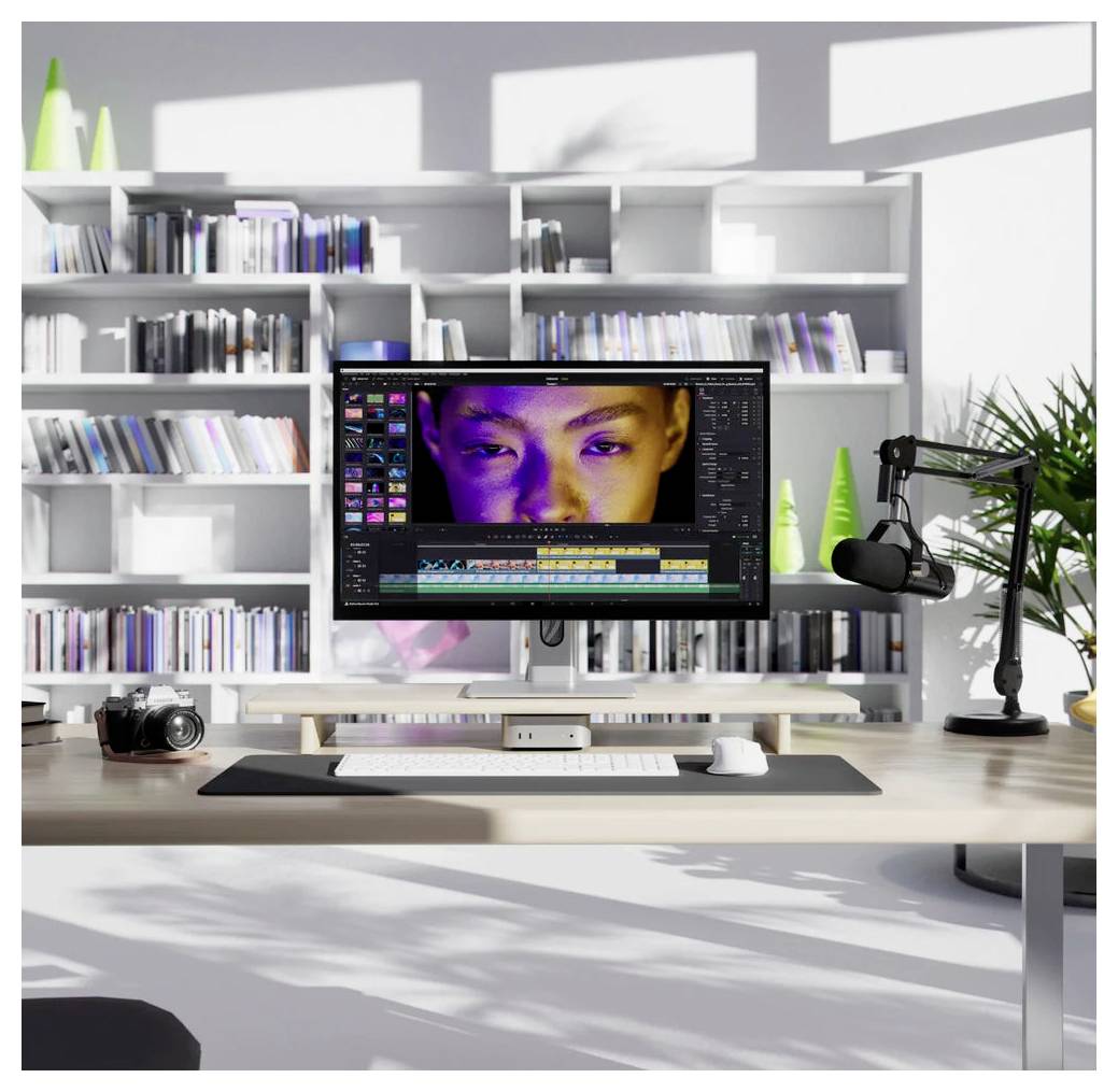 Moderner Bearbeitungsschreibtisch mit einem Monitor, auf dem Videobearbeitungssoftware und ein Nahaufnahmebild eines Gesichts in der Zeitleiste angezeigt werden, sowie eine Kamera und ein Mikrofon in einem hellen Studio-Büro.