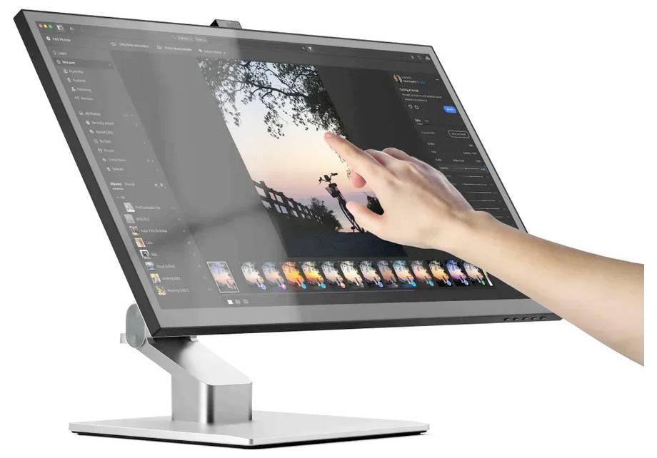 Eine Hand verwendet Touch-Gesten auf einem großen Monitor, der eine Fotobearbeitungsoberfläche mit einem Sonnenuntergangsbild und Bearbeitungssteuerelementen anzeigt.