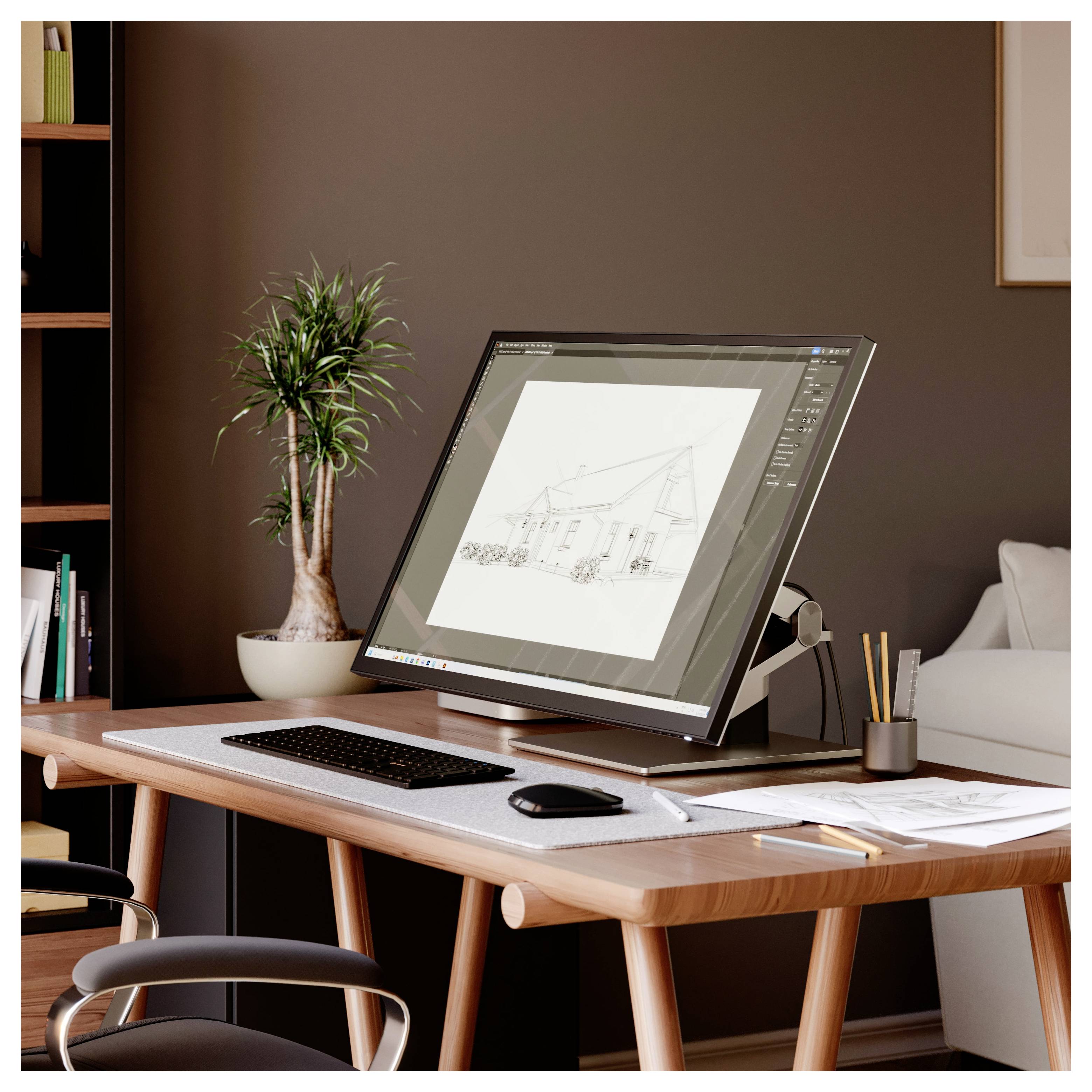 Schreibtisch eines Architekten mit einem großen Monitor, auf dem eine Hauszeichnung angezeigt wird, Tastatur, Maus und Papiere neben einer Topfpflanze in einem Homeoffice.