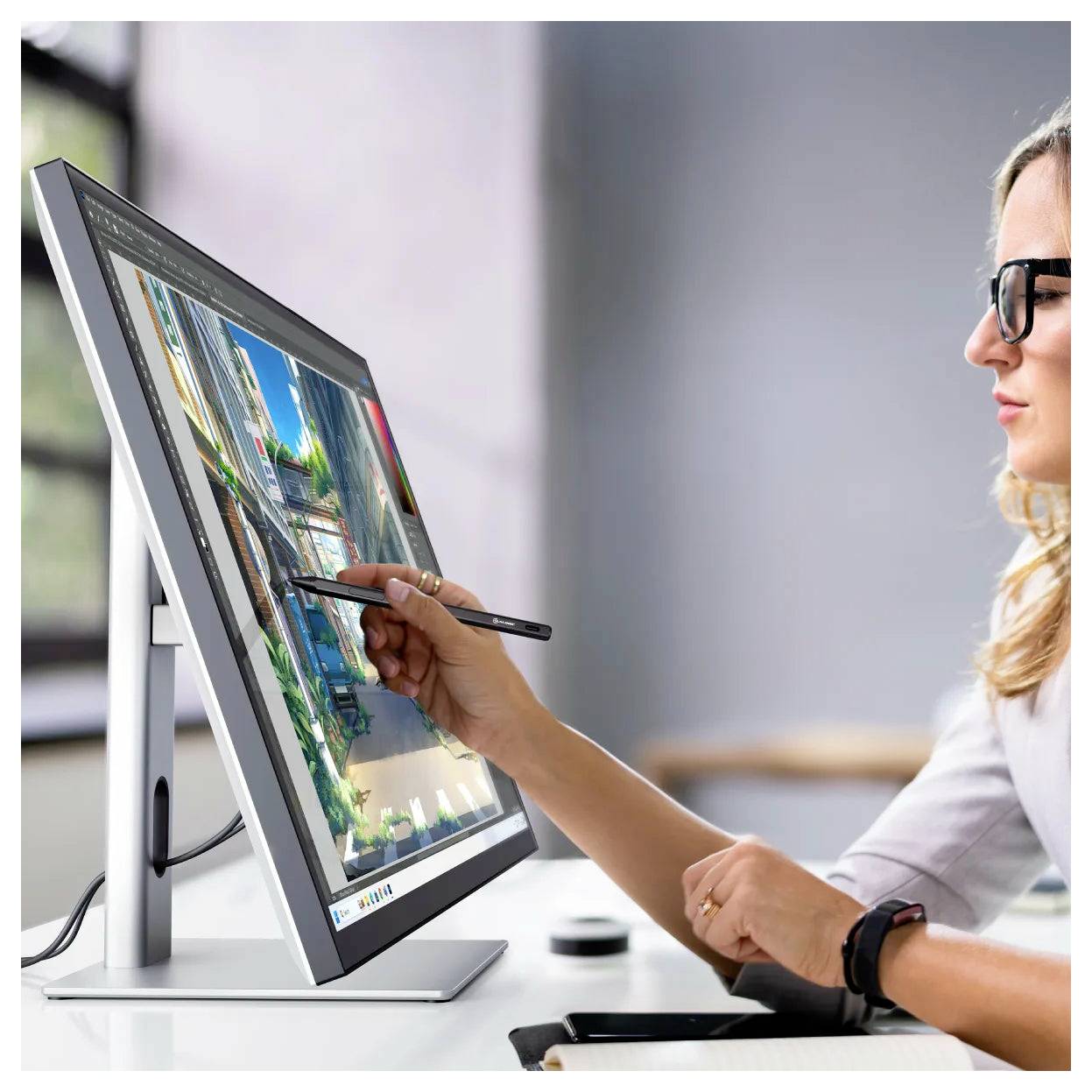 Frau, die mit einem Stylus auf einem Desktop-Touchscreen-Monitor arbeitet und ein Gebäude- oder Landschaftsbild in einem Design-Arbeitsbereich bearbeitet.