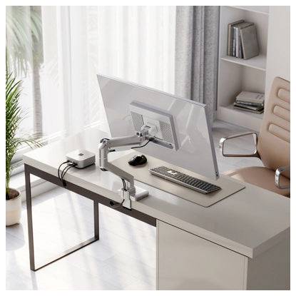 Modernes Homeoffice mit einem großen Monitor auf einem Schwenkarm, Tastatur und Maus auf einem minimalistischen Schreibtisch neben einem Fenster und Regalen.