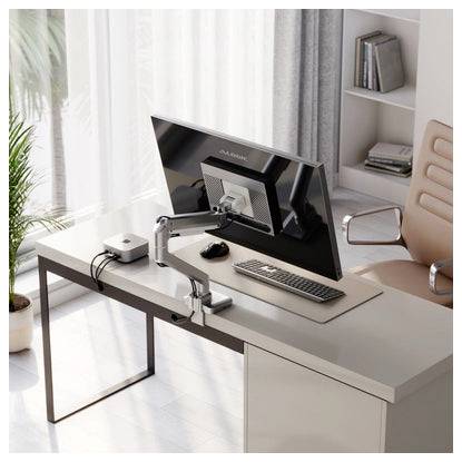 Modernes Homeoffice mit einem Schreibtisch, Monitor auf einer Schwenkarmhalterung, Tastatur, Maus und Stuhl neben einem hellen Fenster und Regalen.