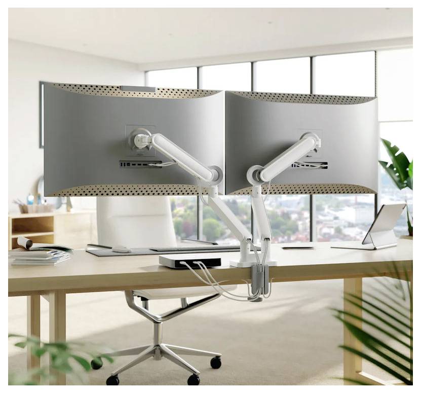 Zwei große Desktop-Monitore auf Gelenkararmen über einem Schreibtisch in einem hellen modernen Arbeitsraum montiert.