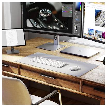 Arbeitsbereich mit zwei Monitoren auf einem Holzschreibtisch mit Tastatur, Maus, Laptop und Tablet; auf einem Bildschirm ist Fotobearbeitungssoftware sichtbar.