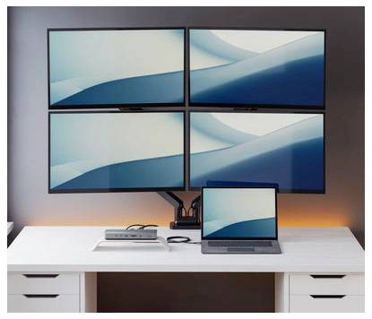 Workstation am Schreibtisch mit vier großen Monitoren in einem 2x2-Gitter und einem Laptop darunter, alle zeigen blaue abstrakte Wellen-Hintergrundbilder.