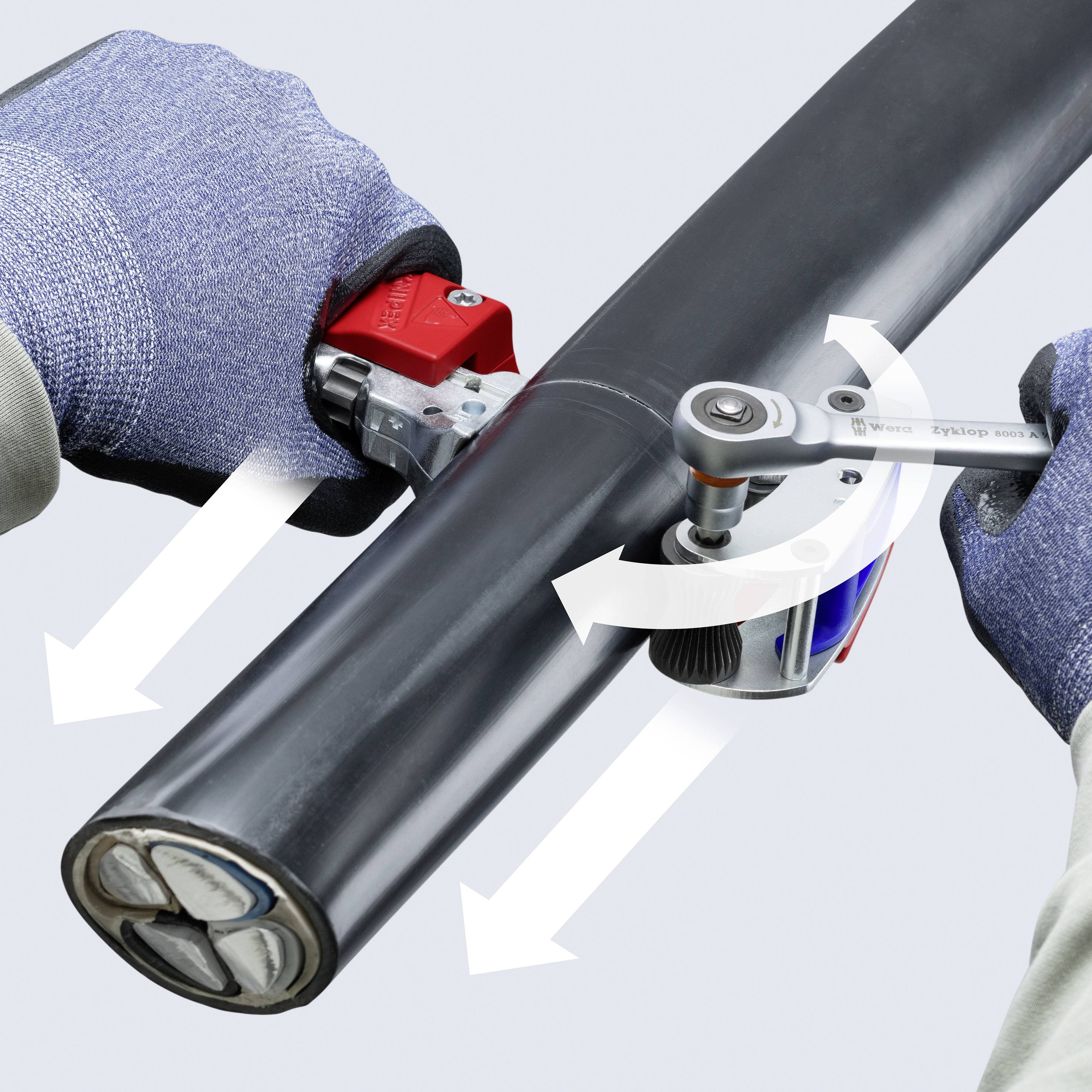 Behandschuhte Hände verwenden einen Rohrabschneider, um ein schwarzes Metallrohr zu schneiden, mit Pfeilen, die zeigen, wie der Abschneider um das Rohr rotiert.