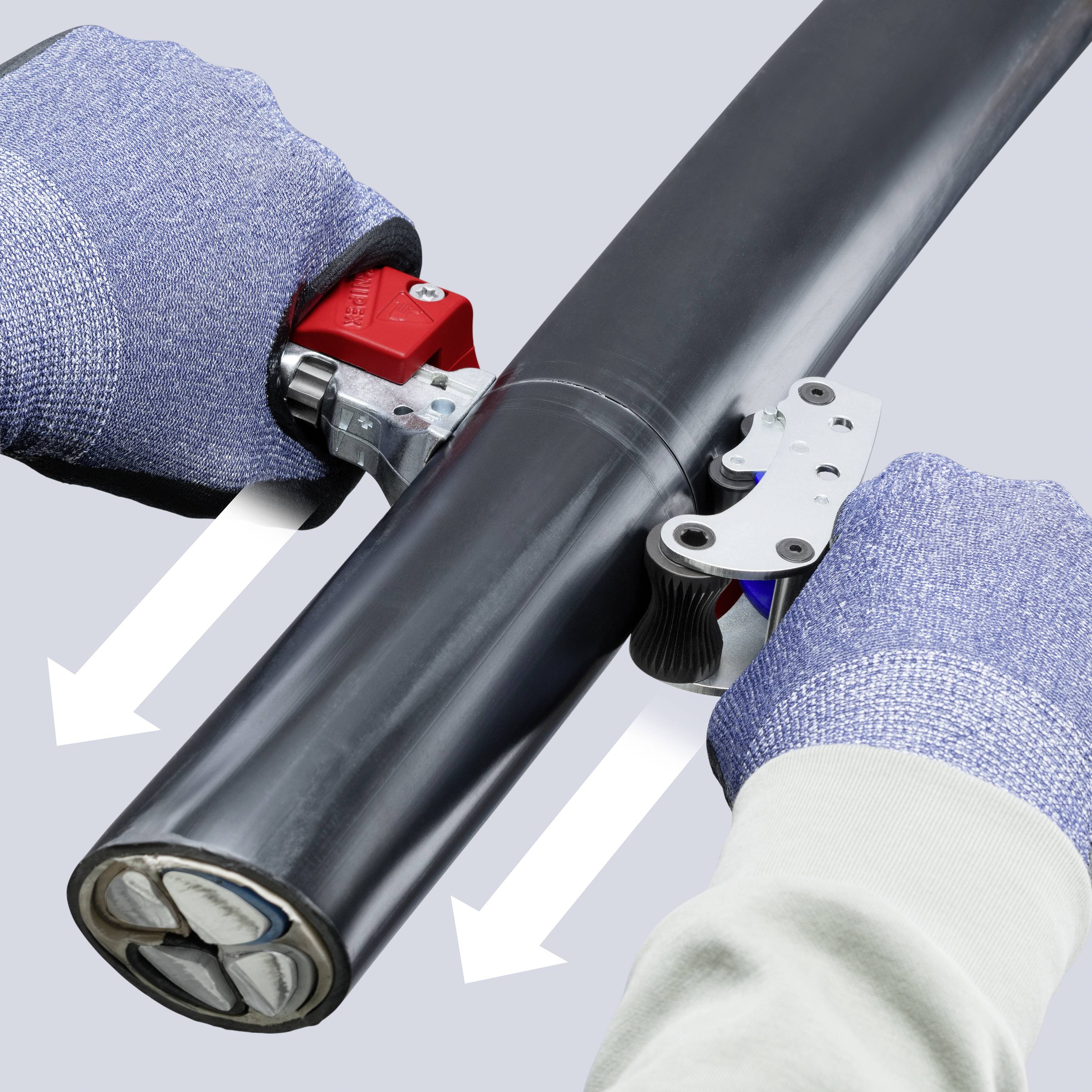 Handschuhe tragende Hände verwenden einen Rotationskabelschneider, um ein schwarzes isoliertes Kabel zu schneiden, wobei weiße Pfeile die Schnittrichtung anzeigen.