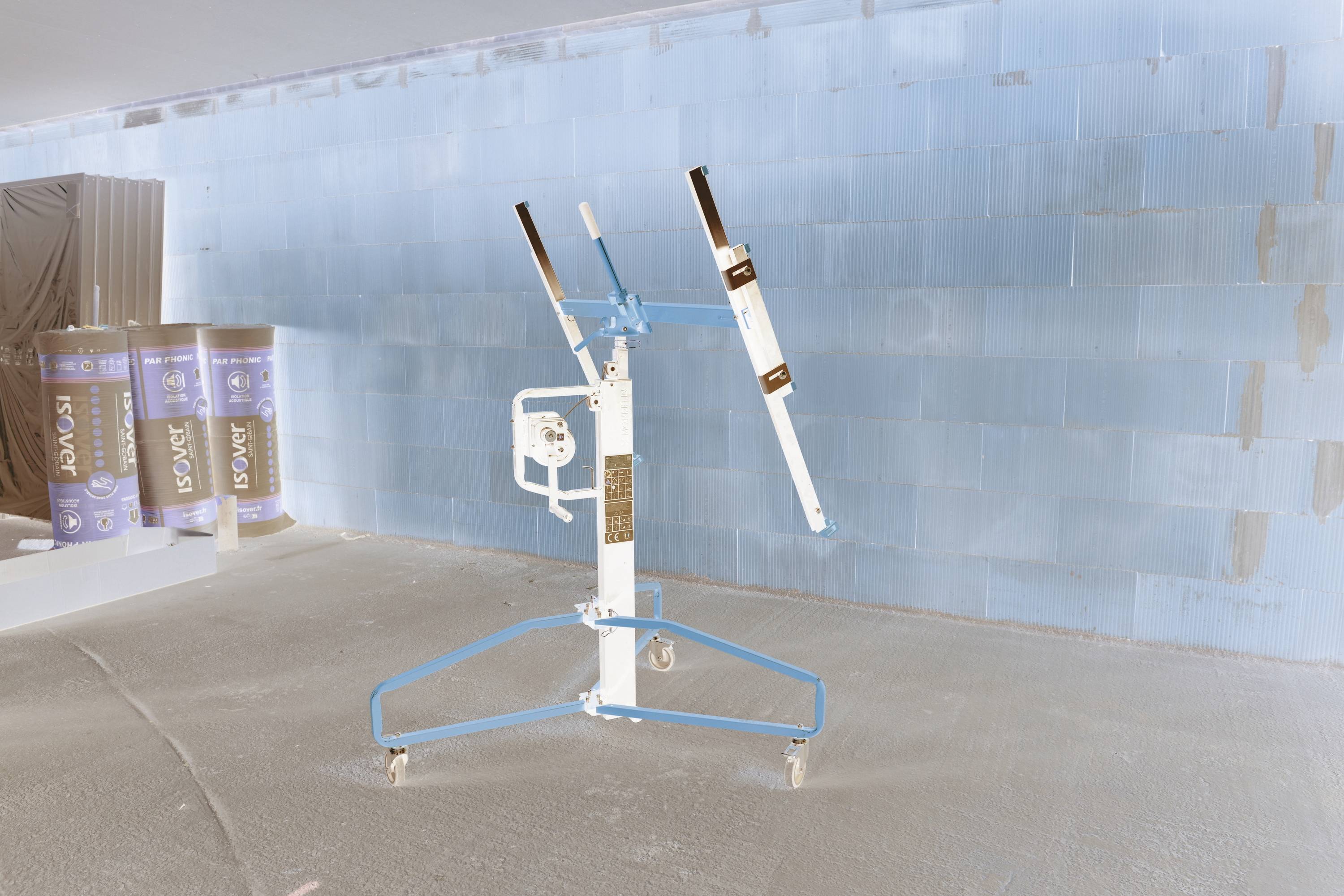 Person, die mit einem Spachtel Spachtelmasse auf eine Wand aufträgt, während einer Trockenbauinstandhaltung