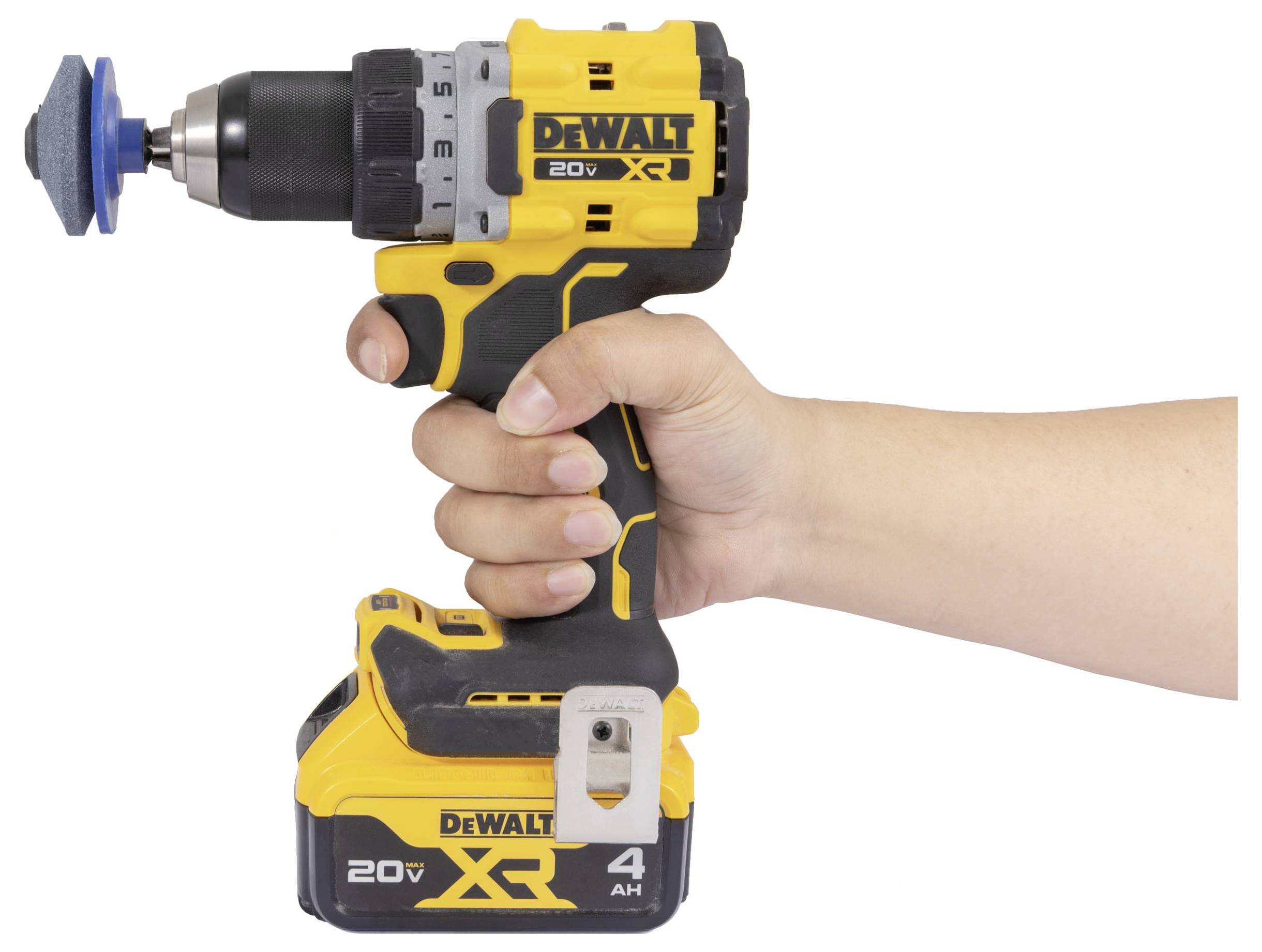 Eine Hand hält einen gelben DeWalt 20V XR Akku-Bohrer mit einer blauen Polier- oder Schleifaufsatz vor einem weißen Hintergrund.