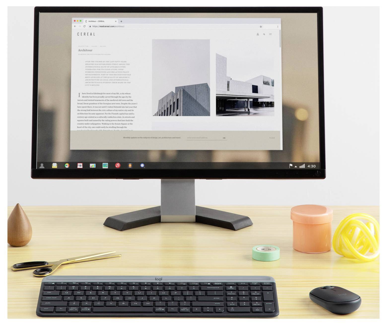 Ein Desktop-Monitor zeigt eine Website mit sauberer Architektur auf einem Schreibtisch mit Tastatur und Maus in einem minimalistischen Arbeitsplatz an.