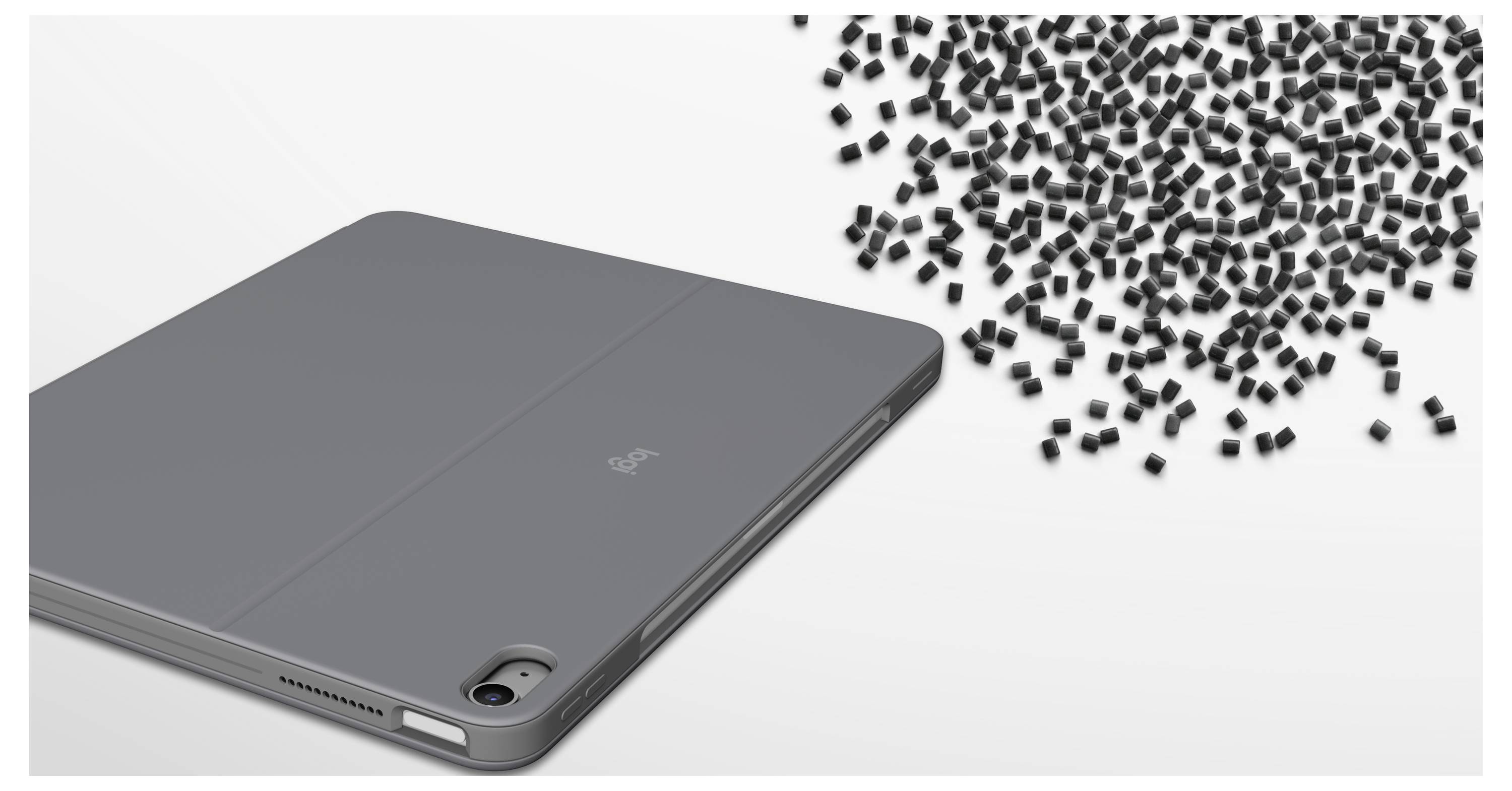 Graues Tablet auf weißem Hintergrund mit vielen winzigen schwarzen Partikeln, die dahinter verschüttet werden und ein beschädigtes oder explodiertes Gerät suggerieren.