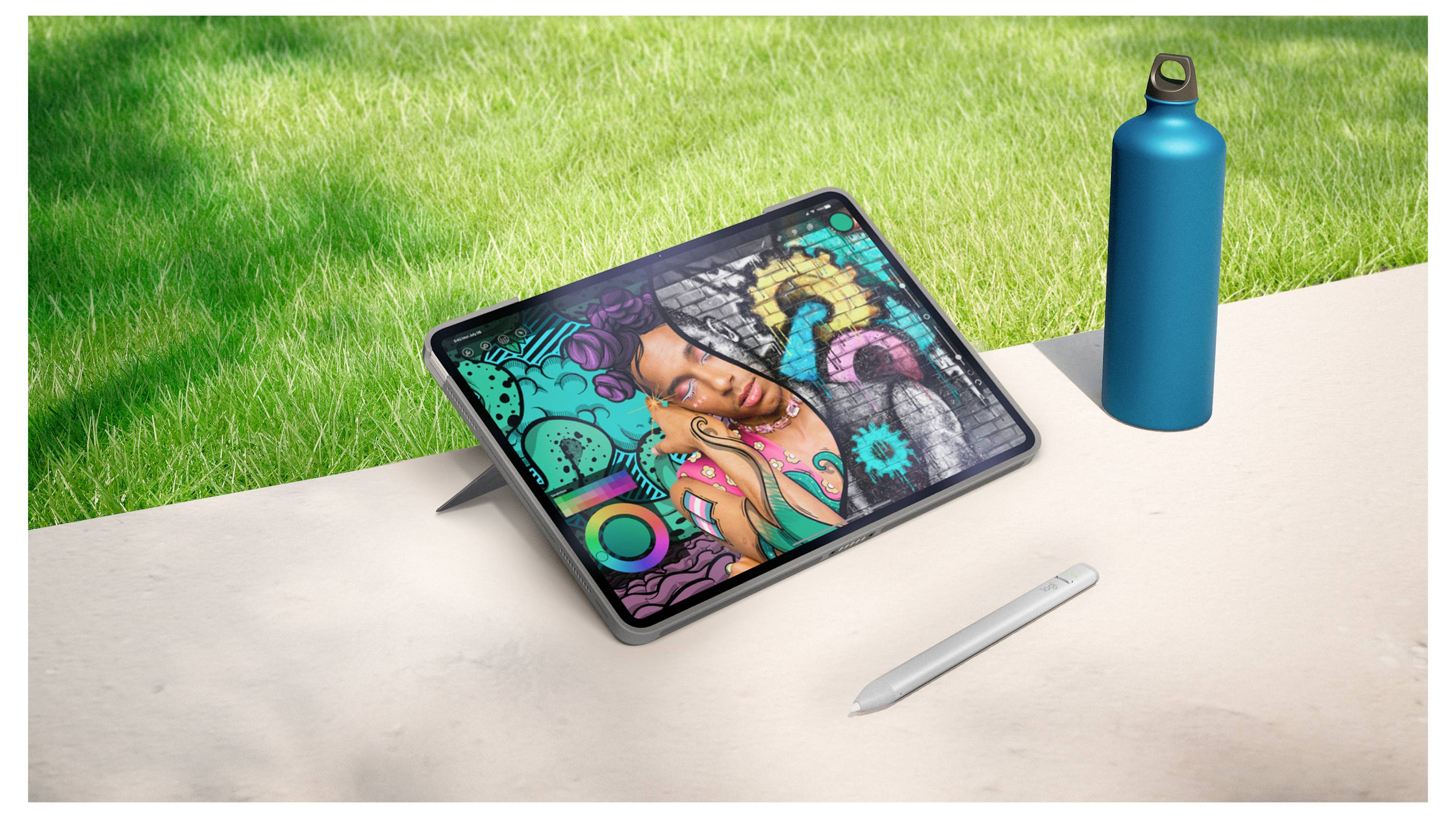 Tablet mit bunter Graffiti-Kunst im angesagten Stil auf einem Ständer neben einem Stift und einer Wasserflasche auf einem Tisch im Freien