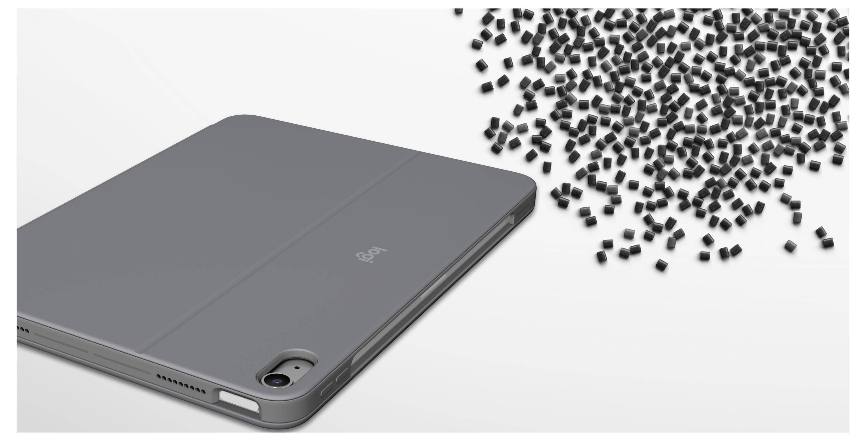 Graues Tablet-Etui, das neben einem verstreuten Haufen kleiner schwarzer Teile auf weißem Hintergrund gezeigt wird, was auf lockere Hardware oder Verschmutzung hindeutet.