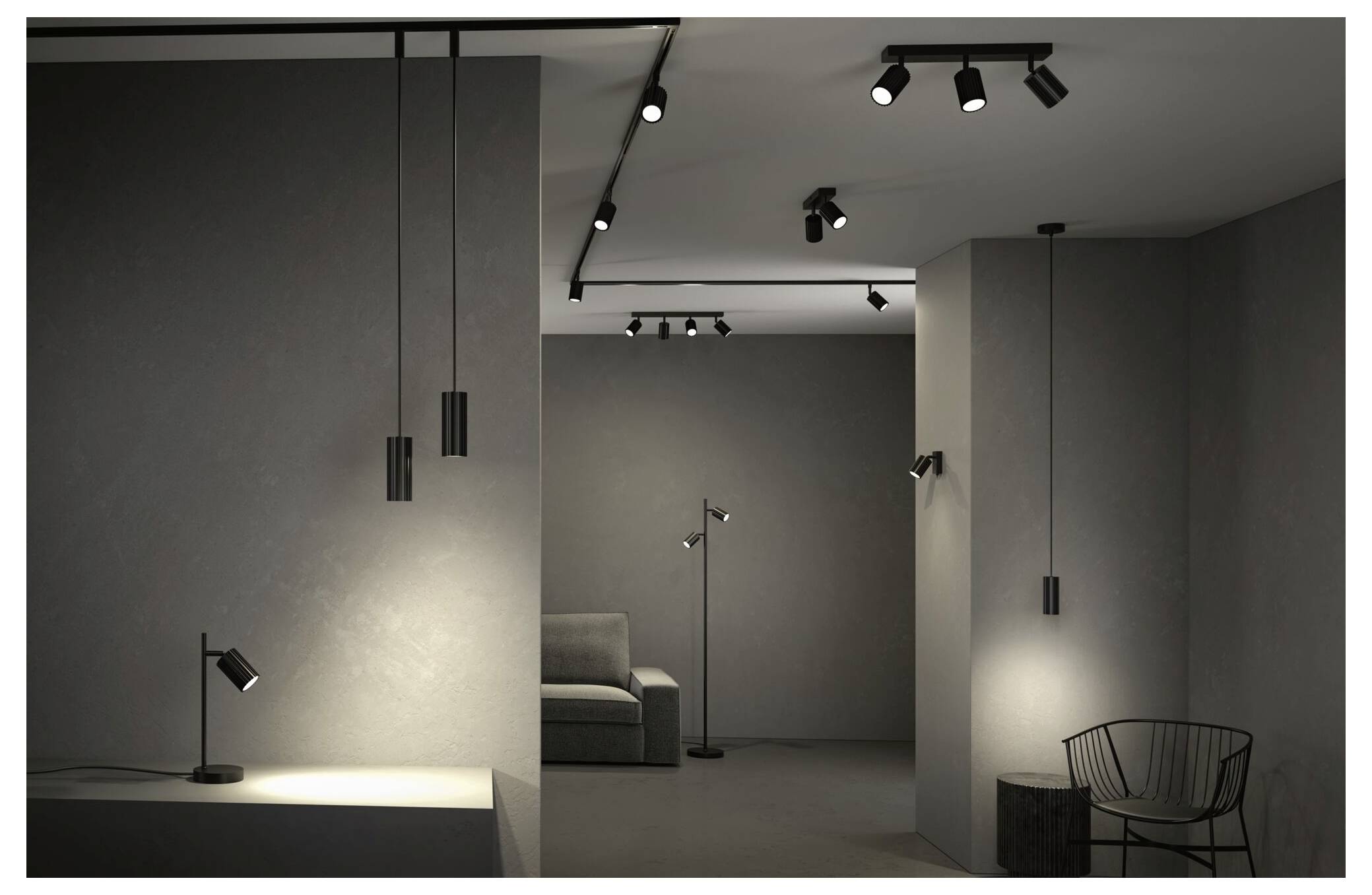 Modernes graues Ausstellungsraum-Interieur mit Schienenlicht, einem Sofa im Hintergrund und einem Drahtstuhl im Vordergrund.