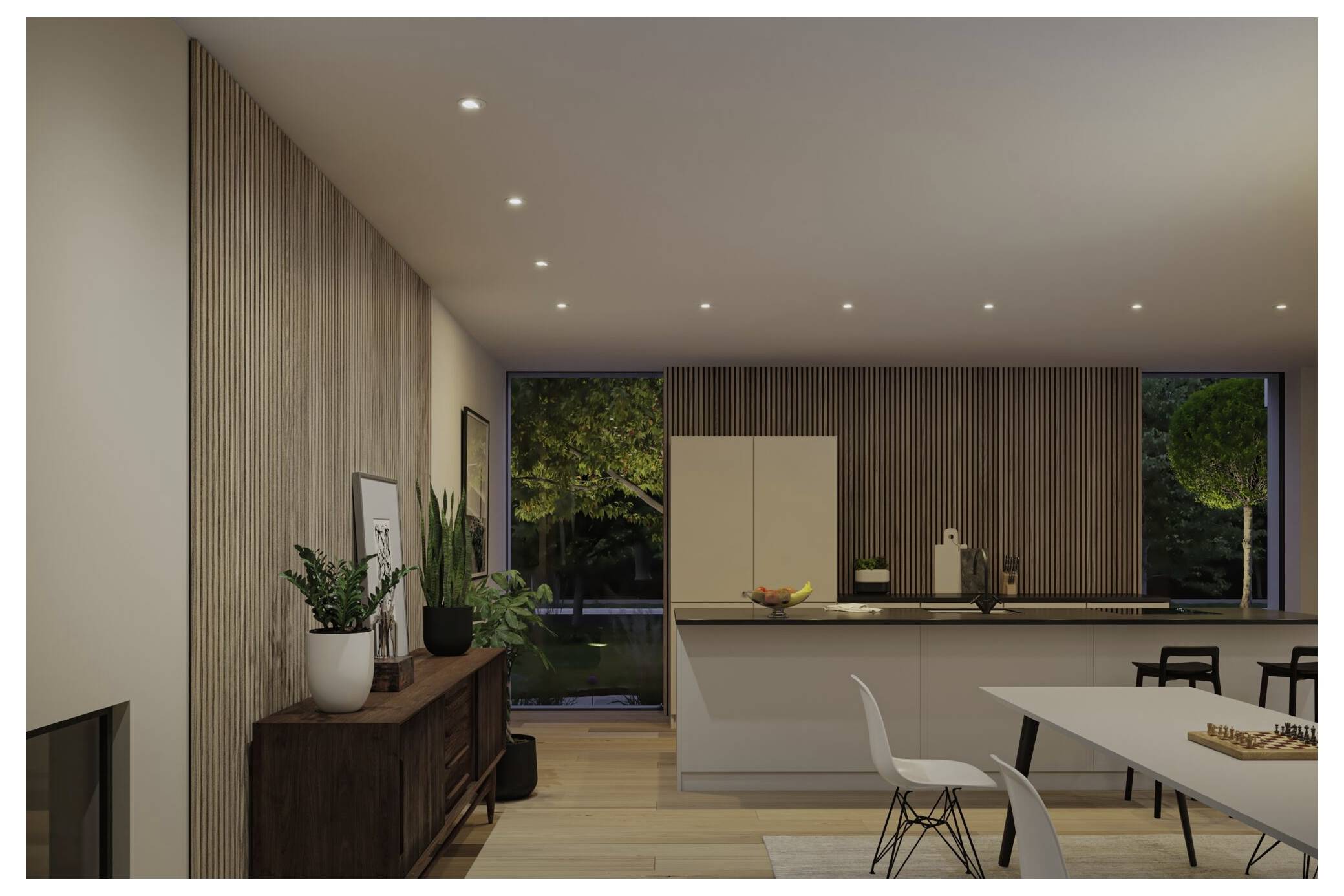 Modernes Ess- und Kücheninterieur in der Abenddämmerung mit Holzlatten-Wandverkleidung, eingelassenen Leuchten, Tisch, Stühlen, Sideboard und großen Fenstern mit Blick auf Bäume.