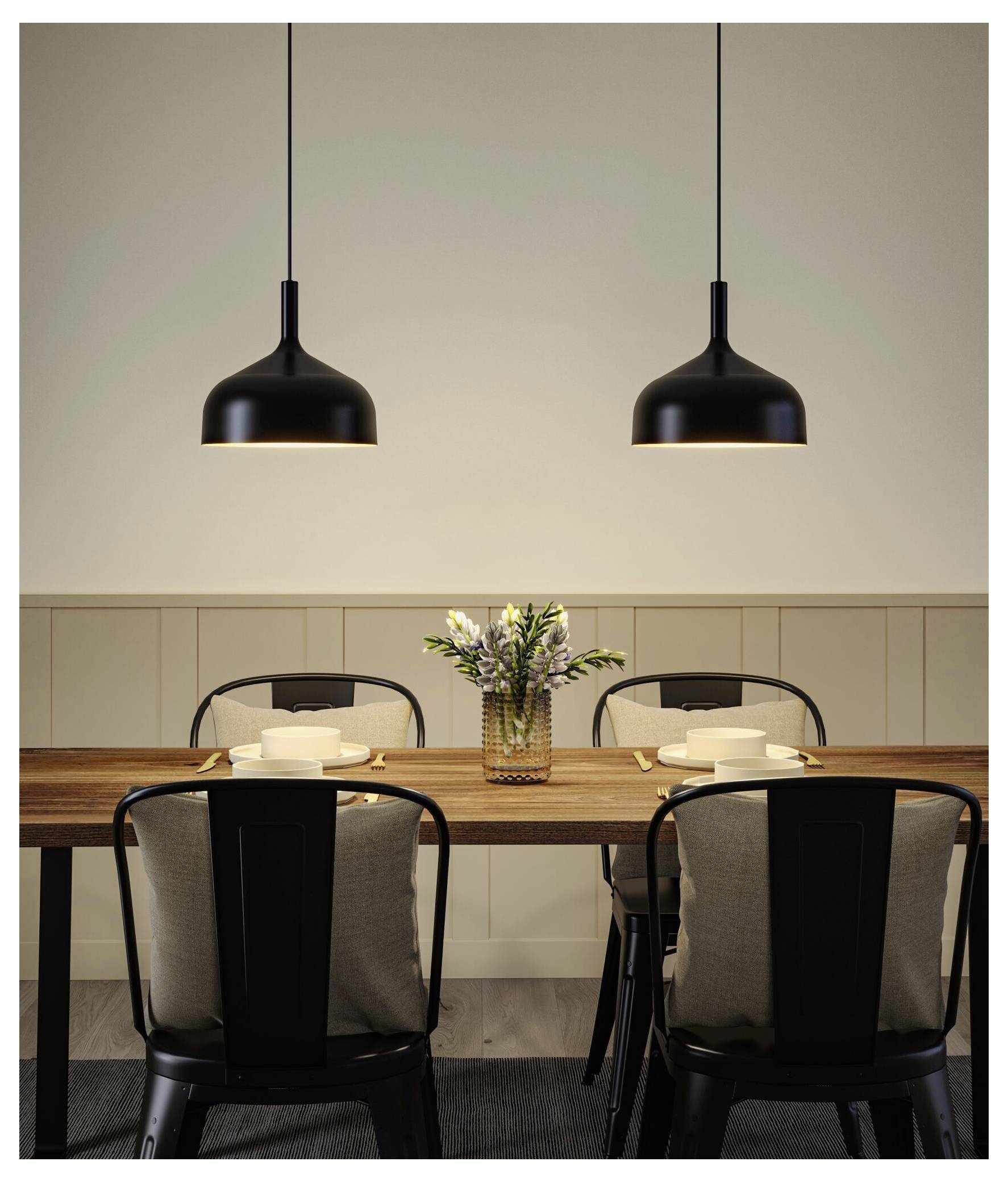 Modernes Esszimmer mit einem Holztisch, gedeckt für vier Personen, unter zwei schwarzen Pendelleuchten, mit einer Blumenvase in der Mitte des Tisches.