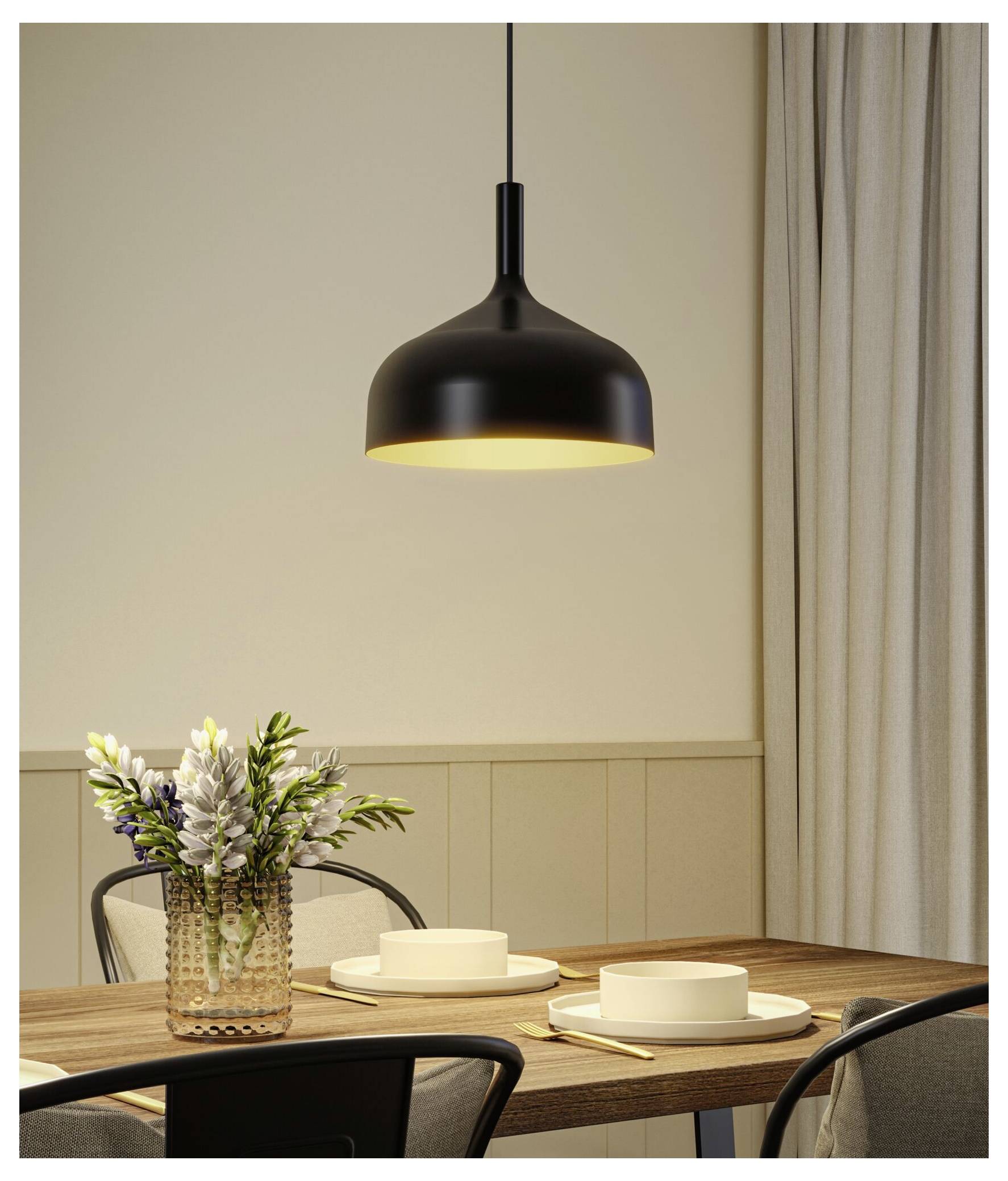 Modernes Esszimmer mit einer schwarzen Hängeleuchte über einem Holztisch mit Tellern, Kerzen, Blumen und Stühlen.